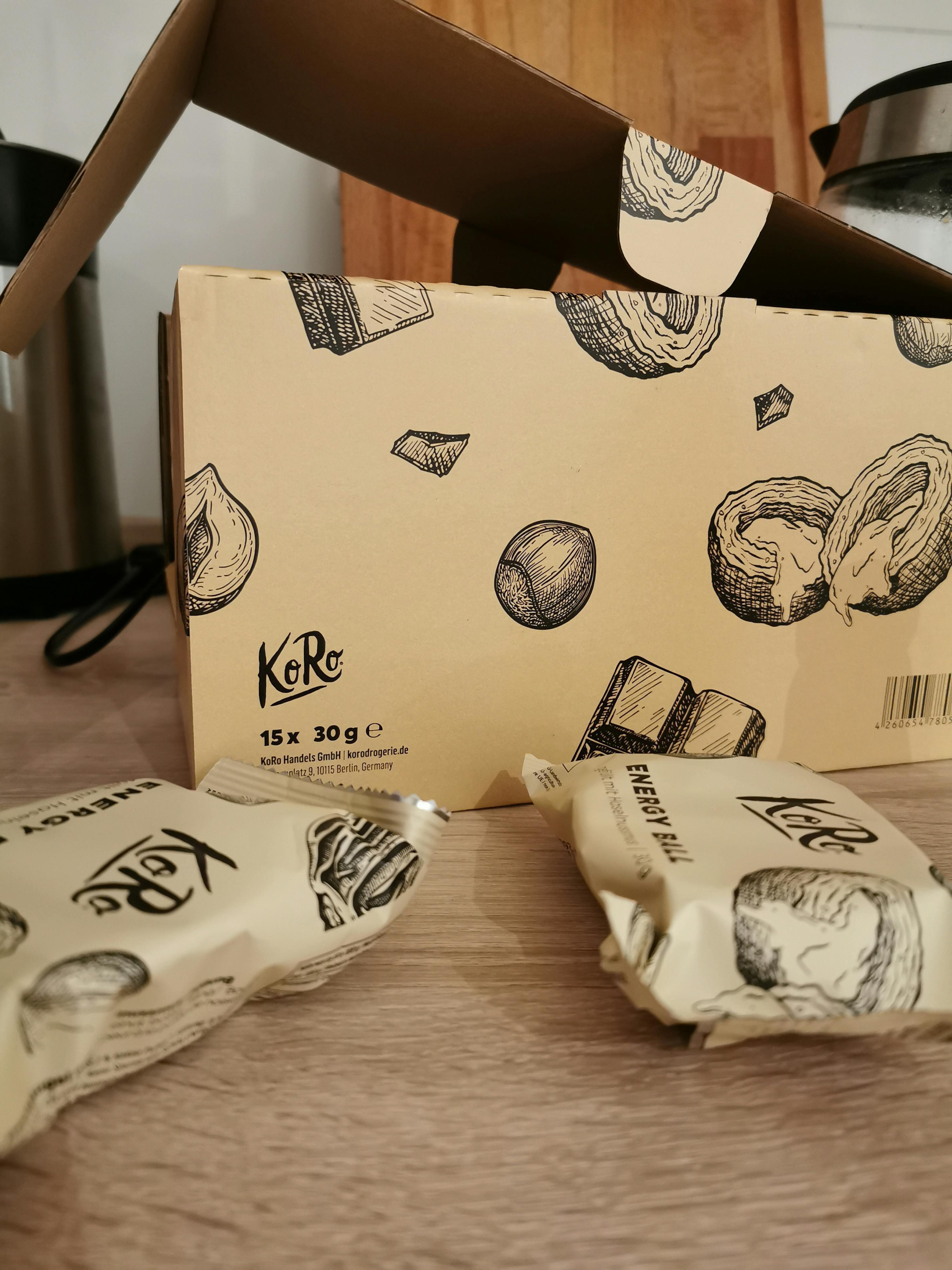 una scatola di cartone con un disegno di nocciole e cioccolato è seduta su un tavolo di legno