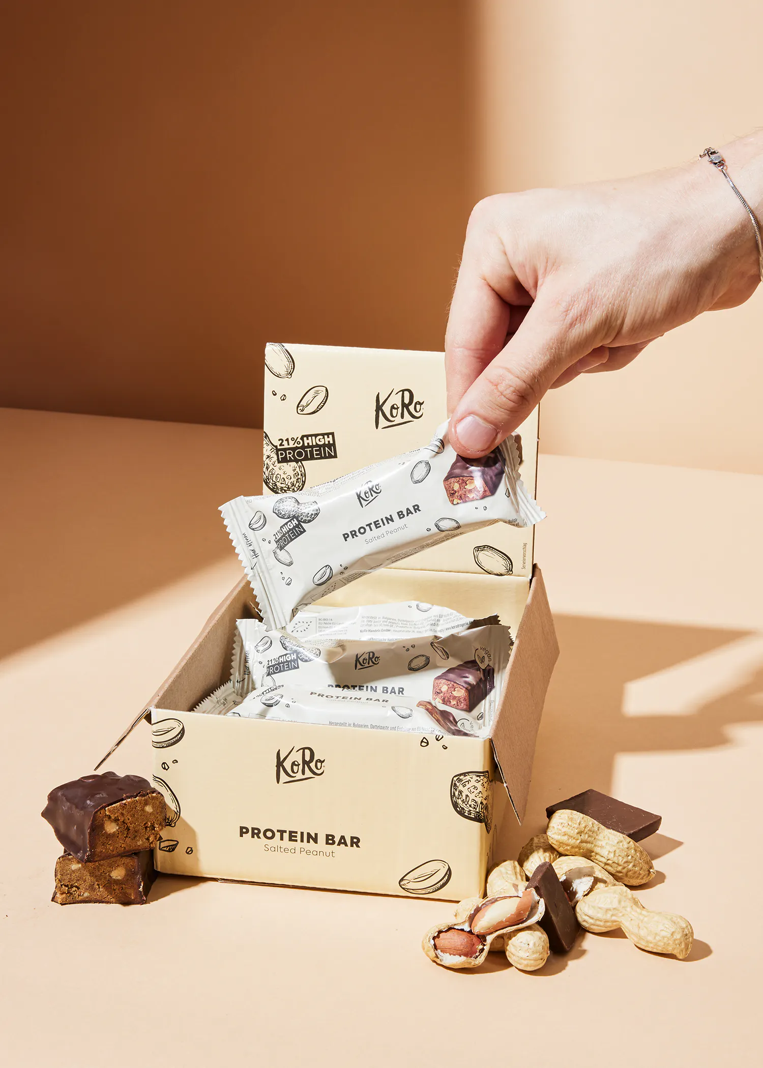 a hand is reaching for a protein bar from a box