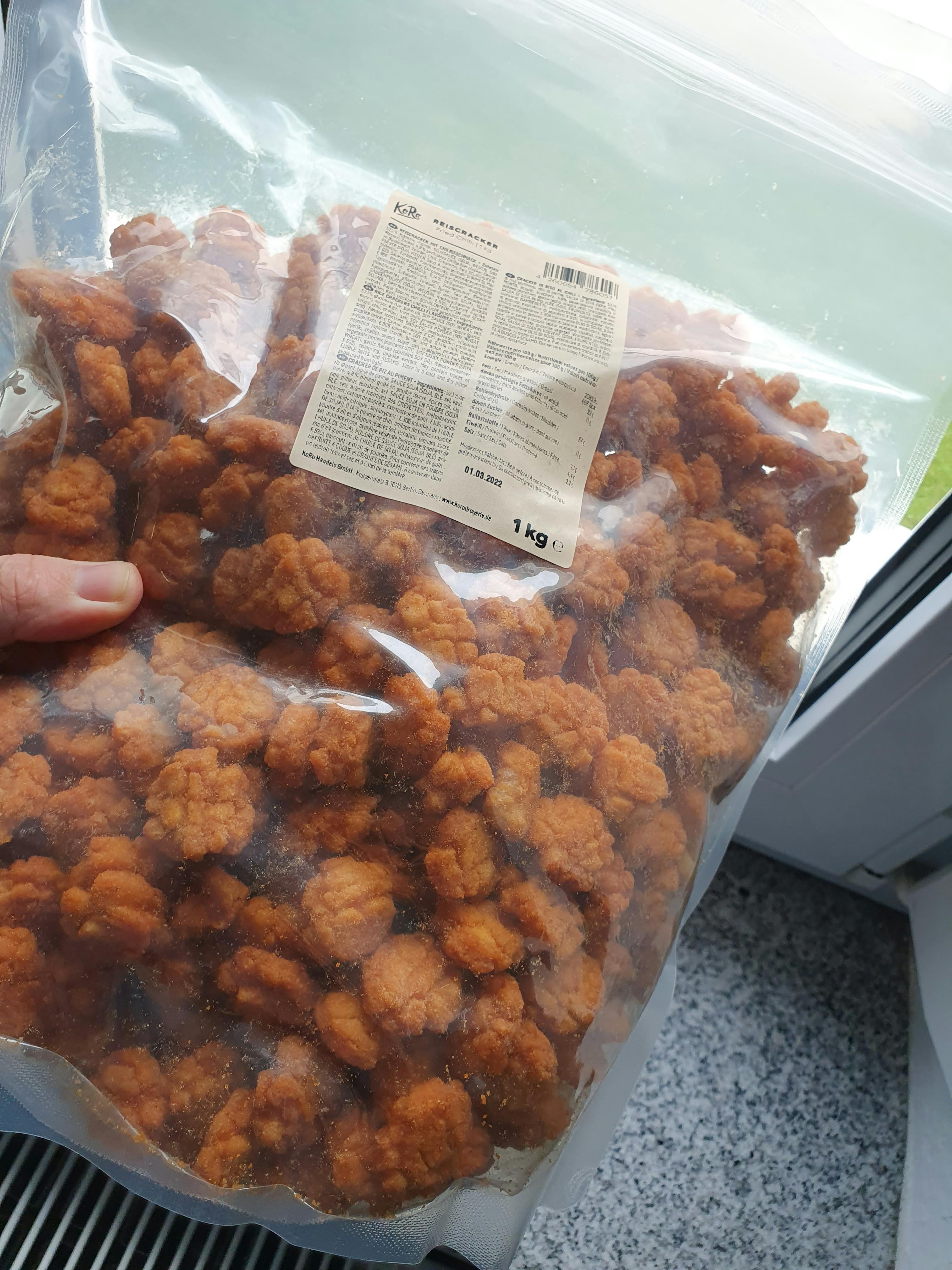 une personne tient un sac en plastique rempli de nourriture