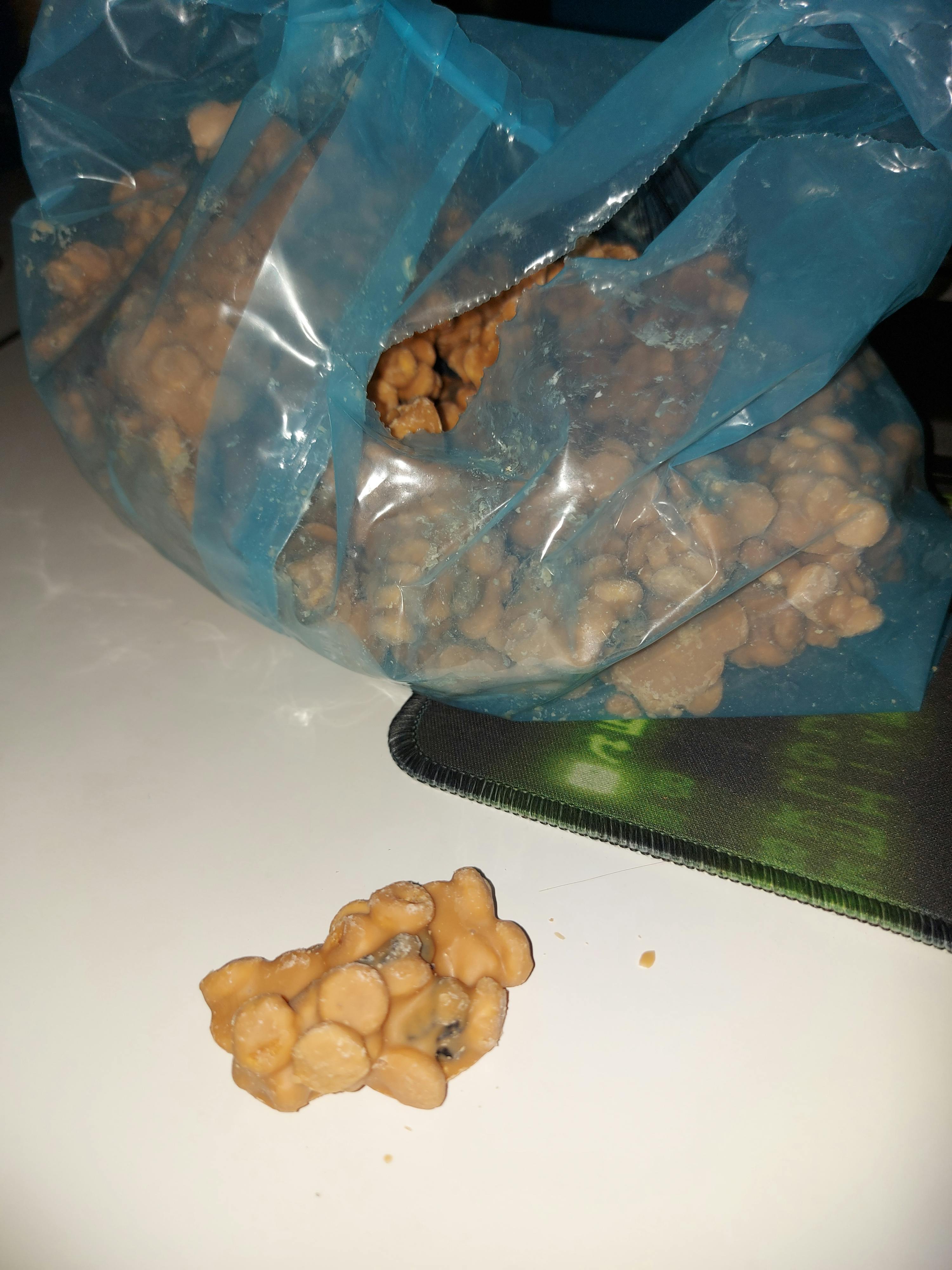 a bag of nuts sits next to a green mouse pad