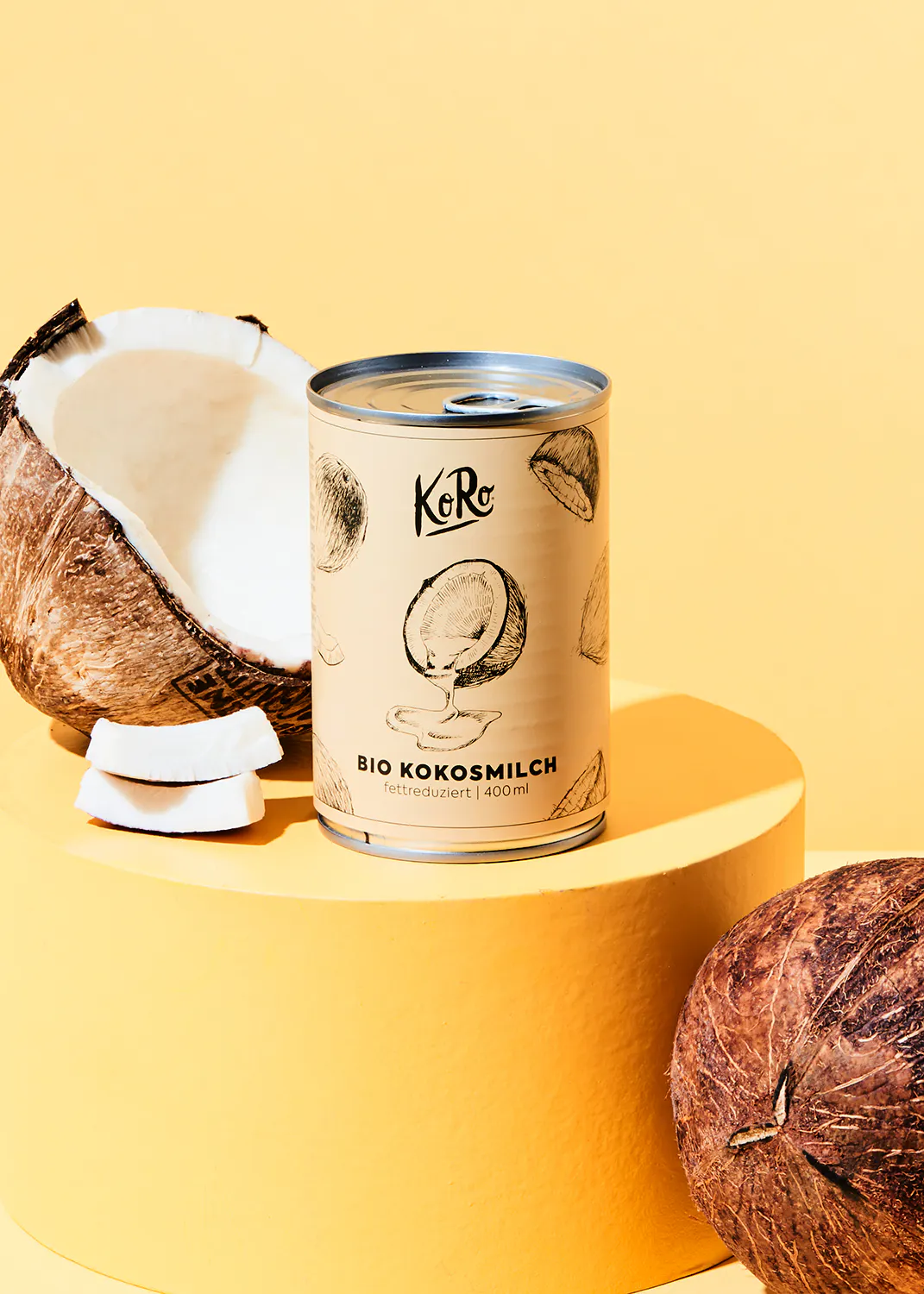 a can of bio kokosmilch sits next to two coconuts