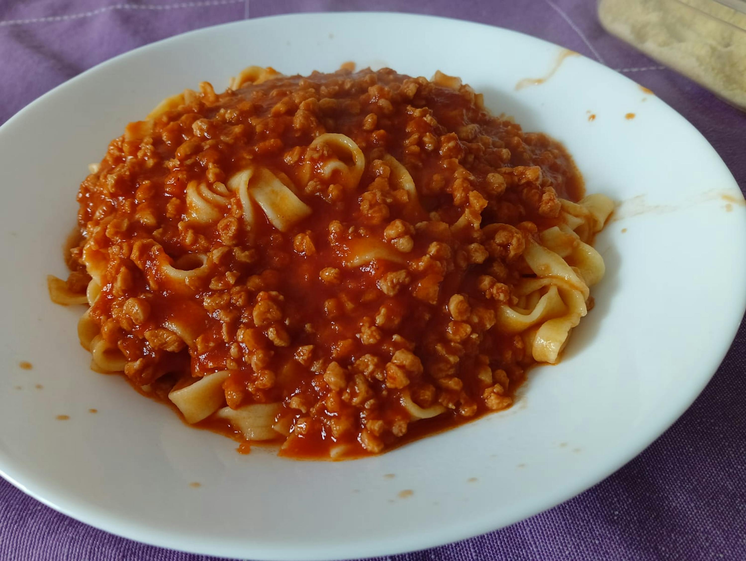 a white plate topped with pasta and meat sauce