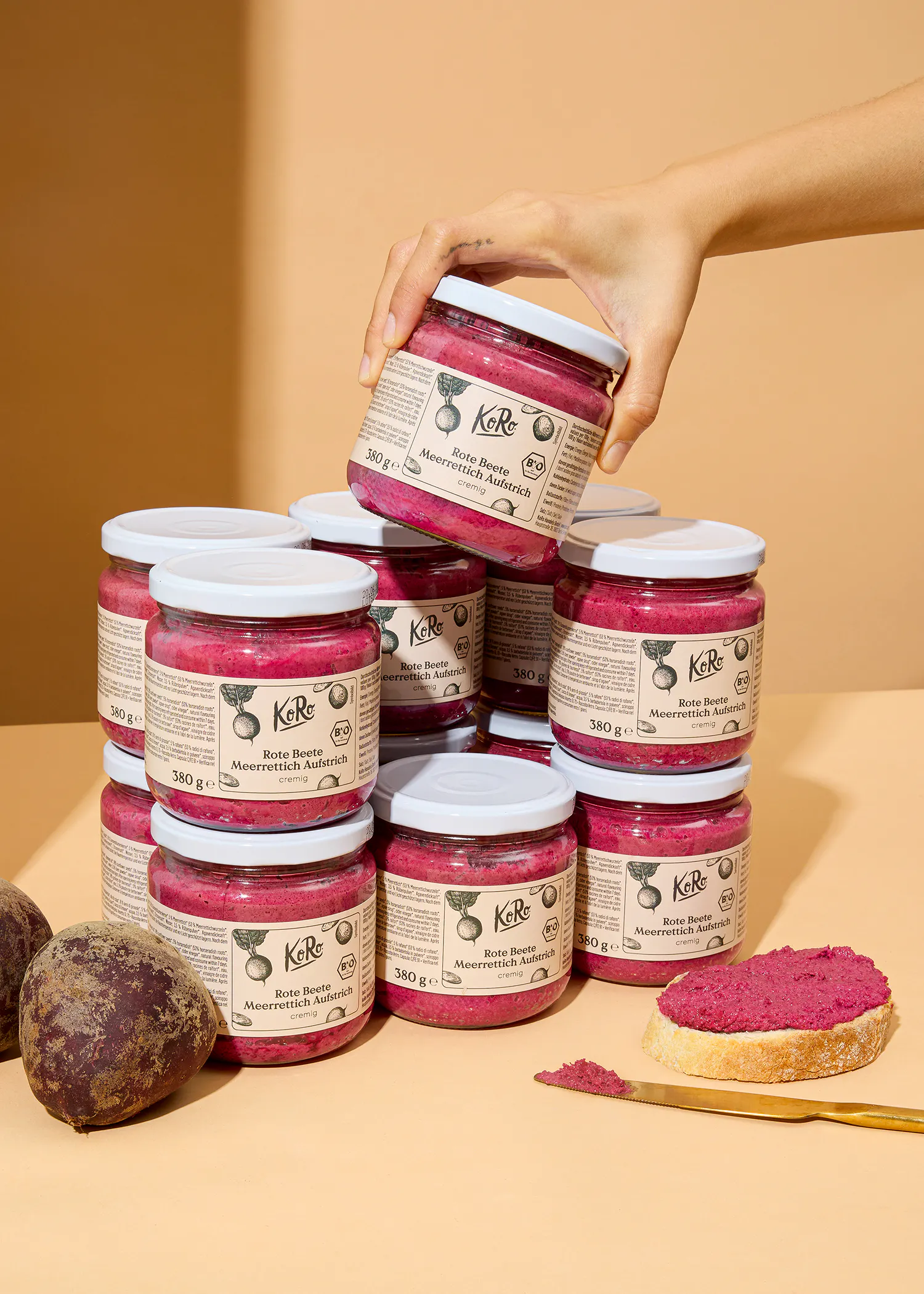 eine hand hält ein glas rote beete marmelade