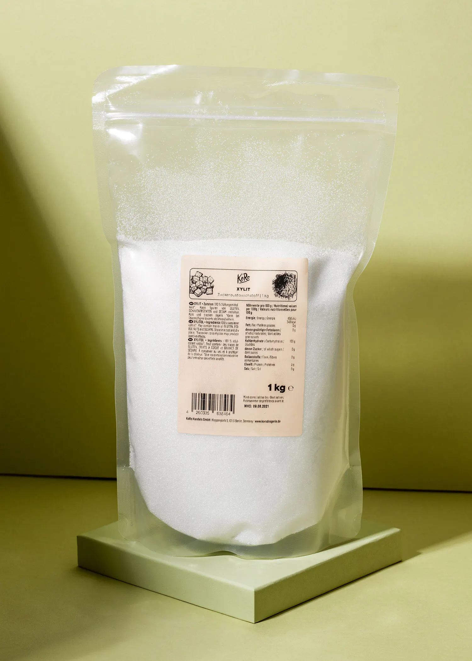 a bag of white sugar is sitting on a green cube