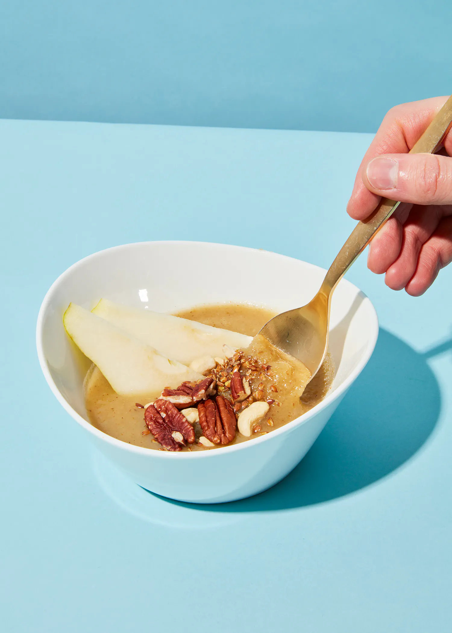 a person is holding a spoon over a bowl of food