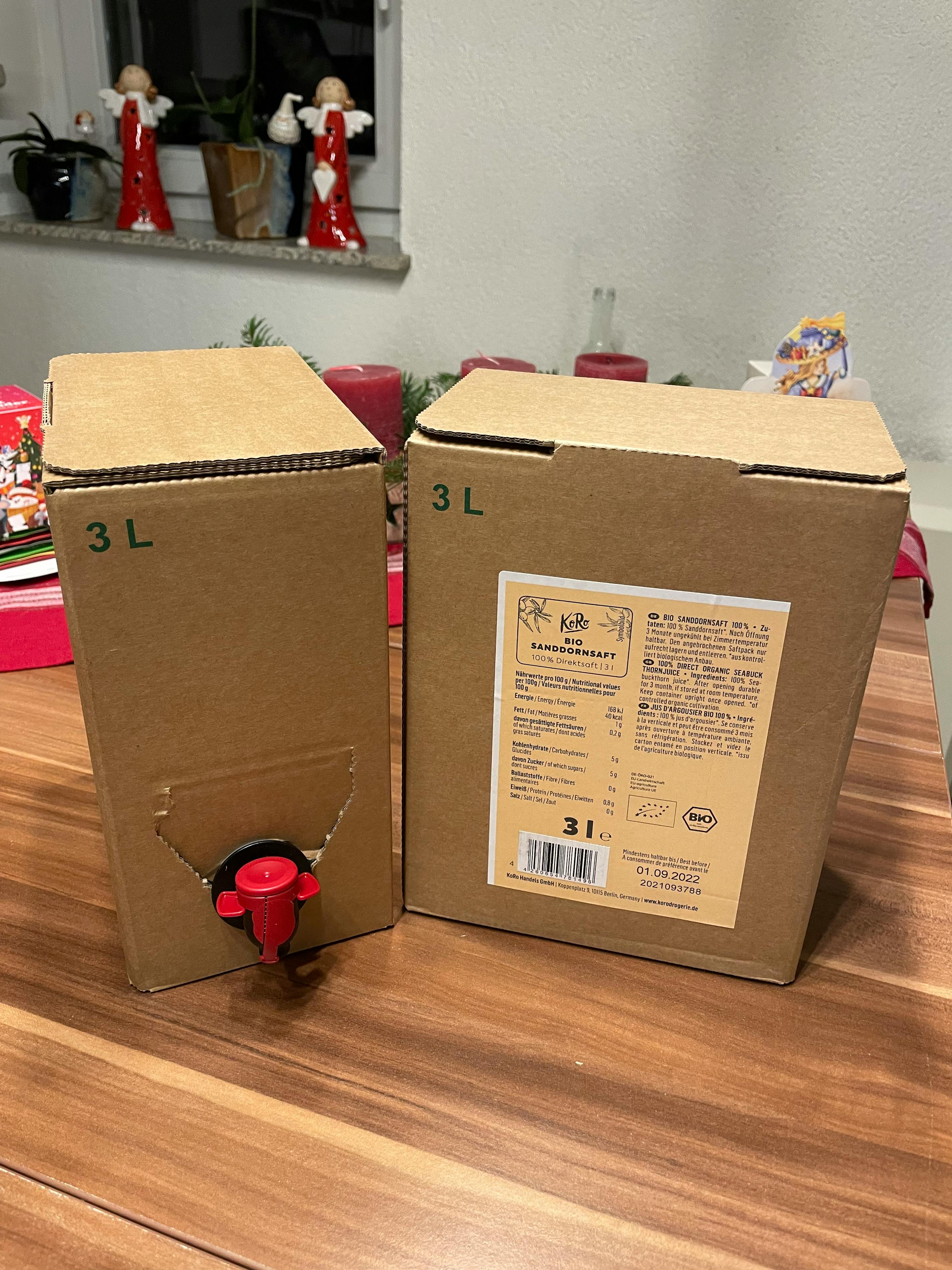 due scatole di cartone con l' etichetta 3l sono sedute su un tavolo di legno