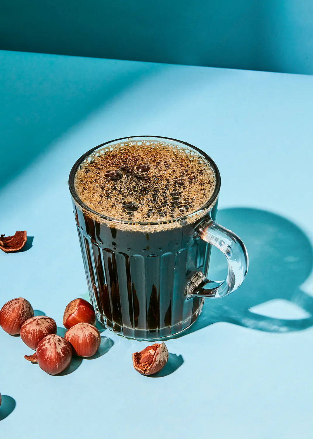 a cup of coffee with nuts next to it