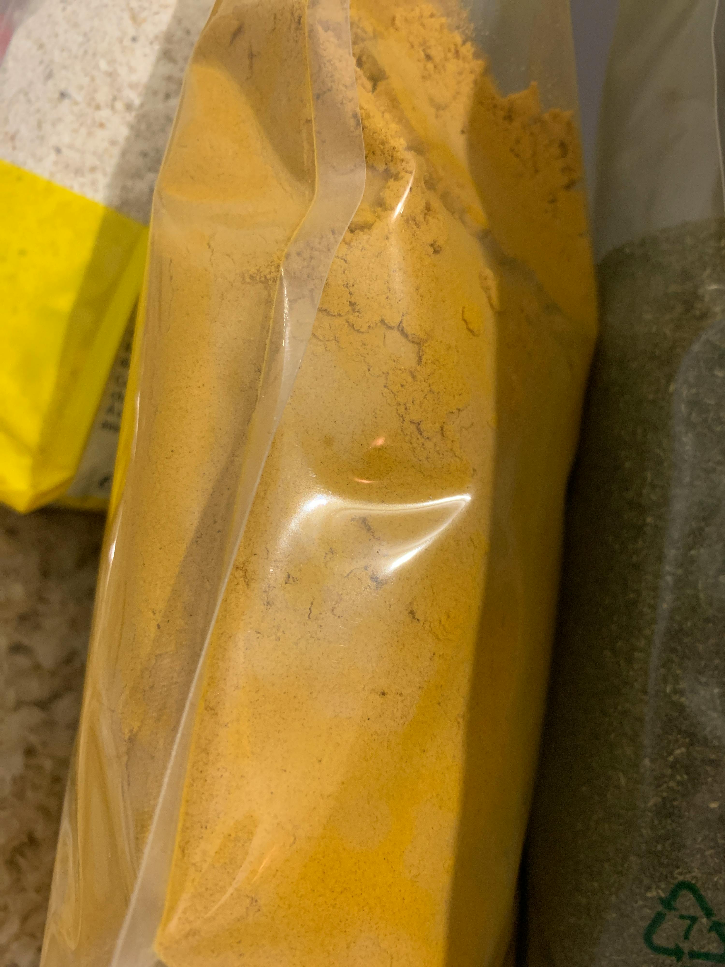 eine Nahaufnahme eines Plastikbeutels mit einem gelben Pulver darin