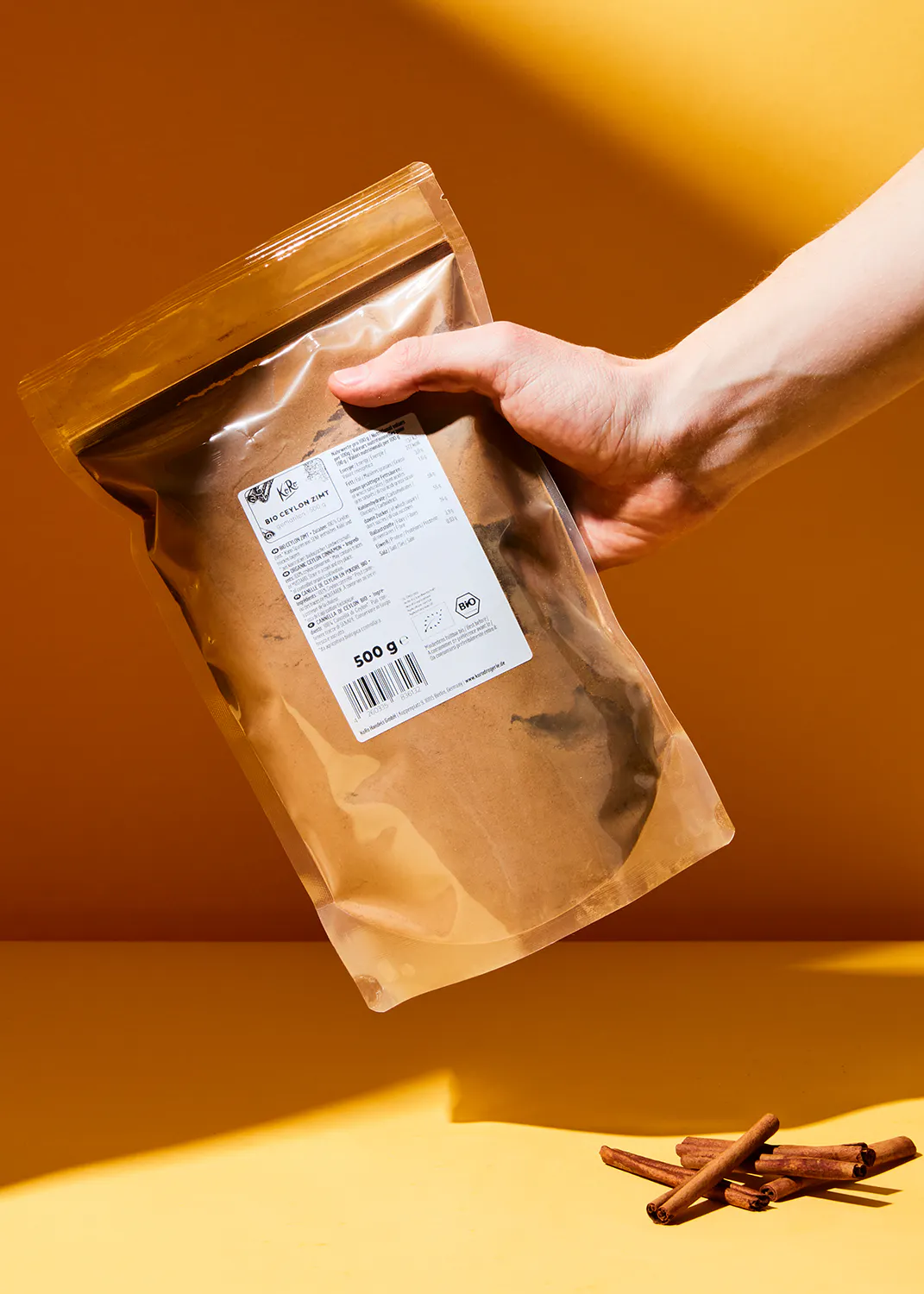 a person is holding a bag of cinnamon powder