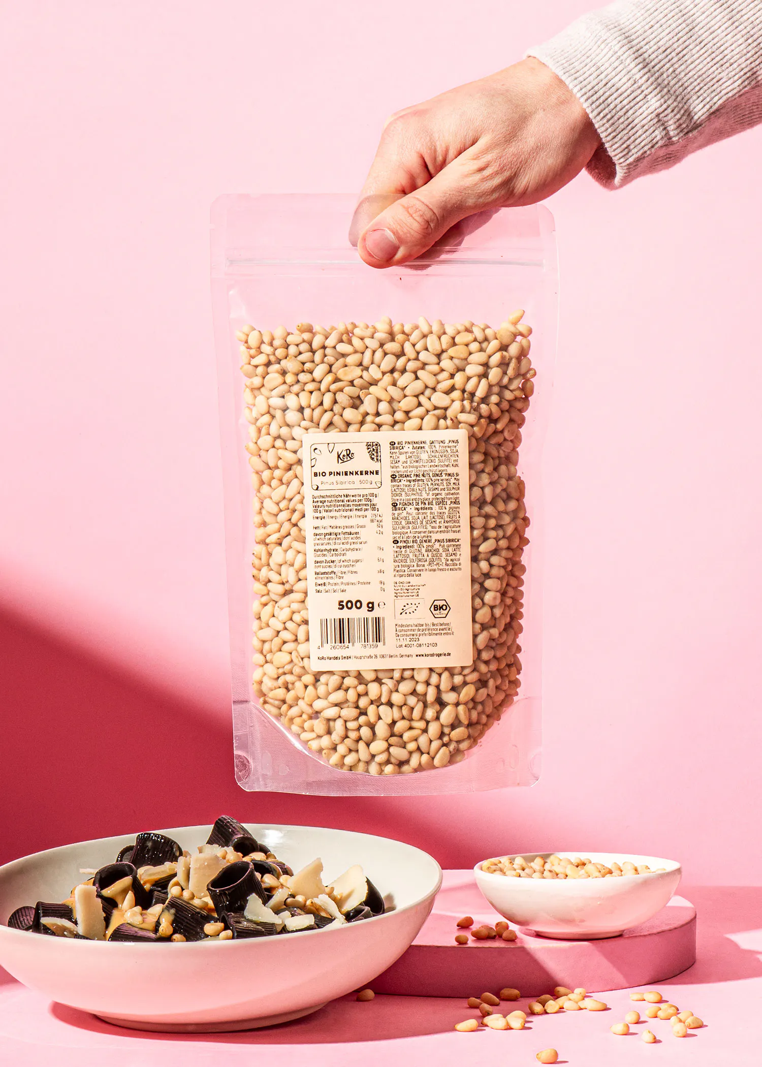 une personne tient un sac de noix de pin à côté d' un bol de noix