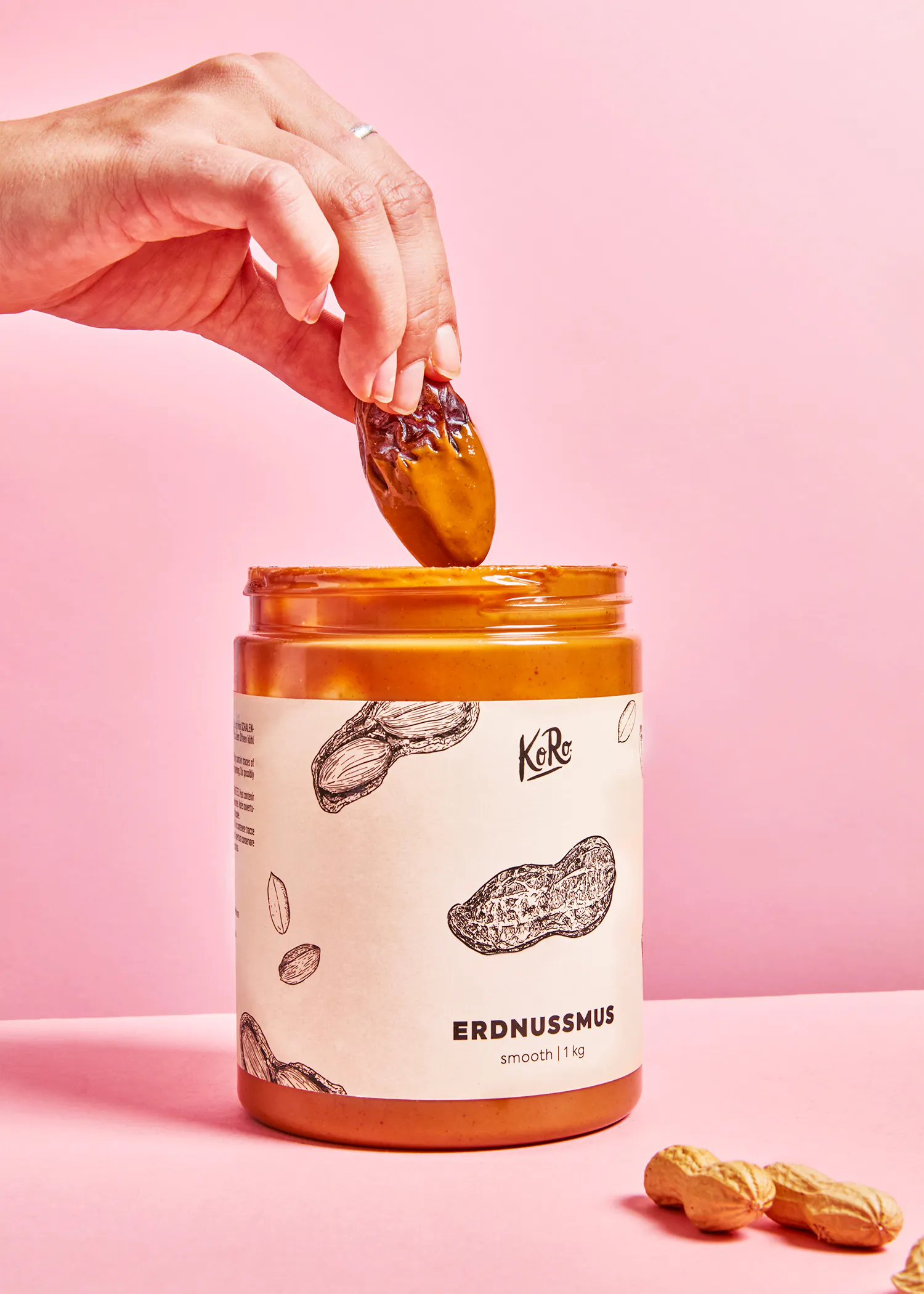 une personne verse un morceau de beurre d' arachide dans un bocal de beurre d' arachide