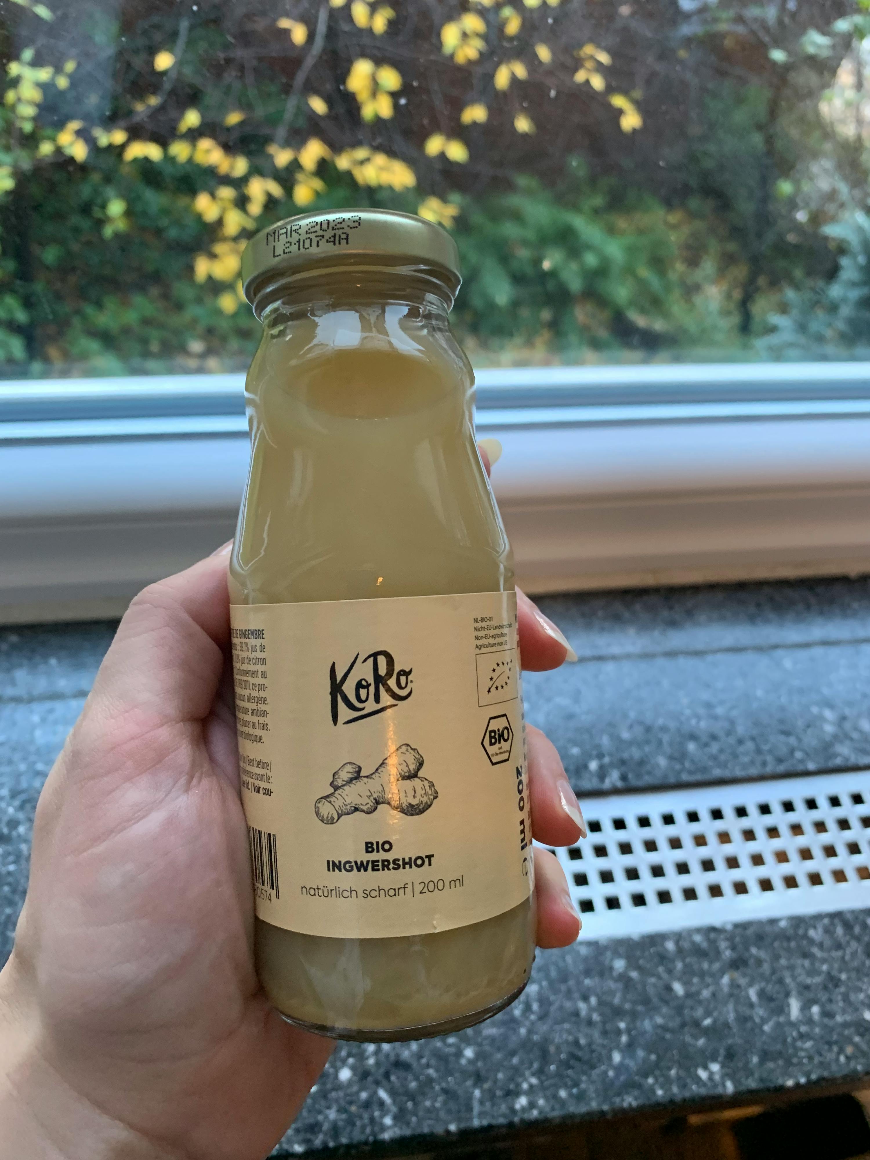 une personne tient une bouteille de boisson au gingembre bio