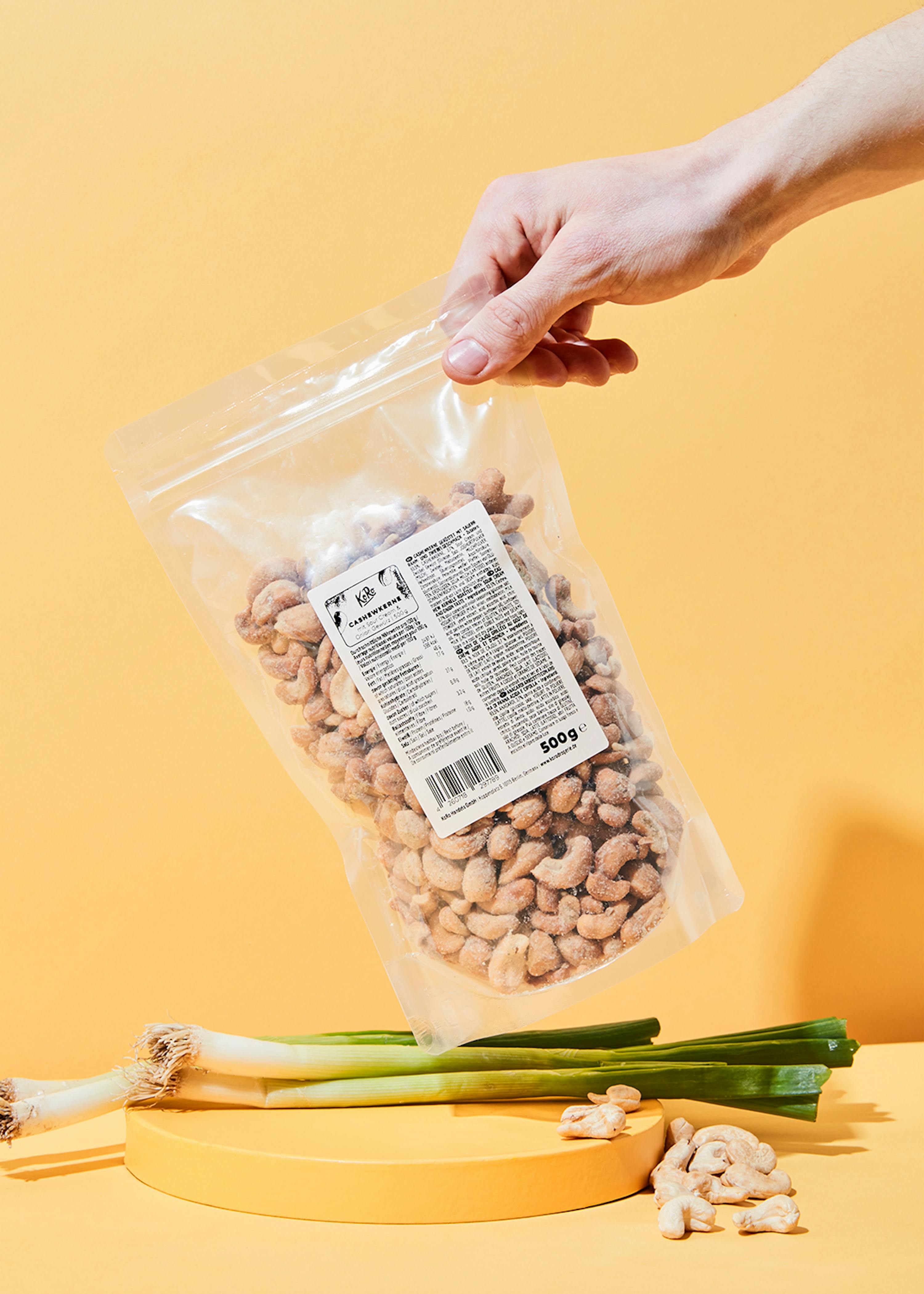 une personne tient un sac de noix de cajou 500g