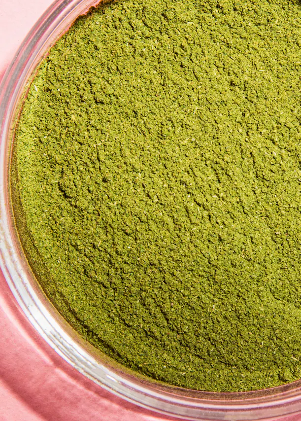 un bol en verre rempli de poudre verte