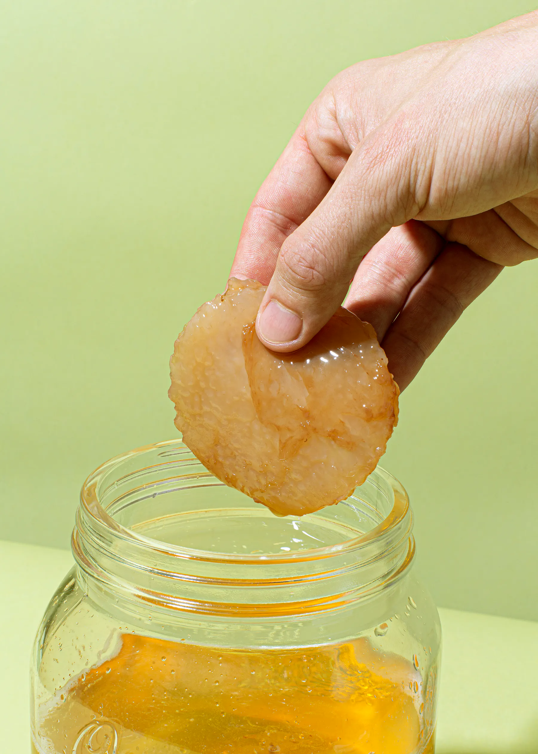 eine Person hält ein Stück Brot in der Hand und legt es in ein Glas