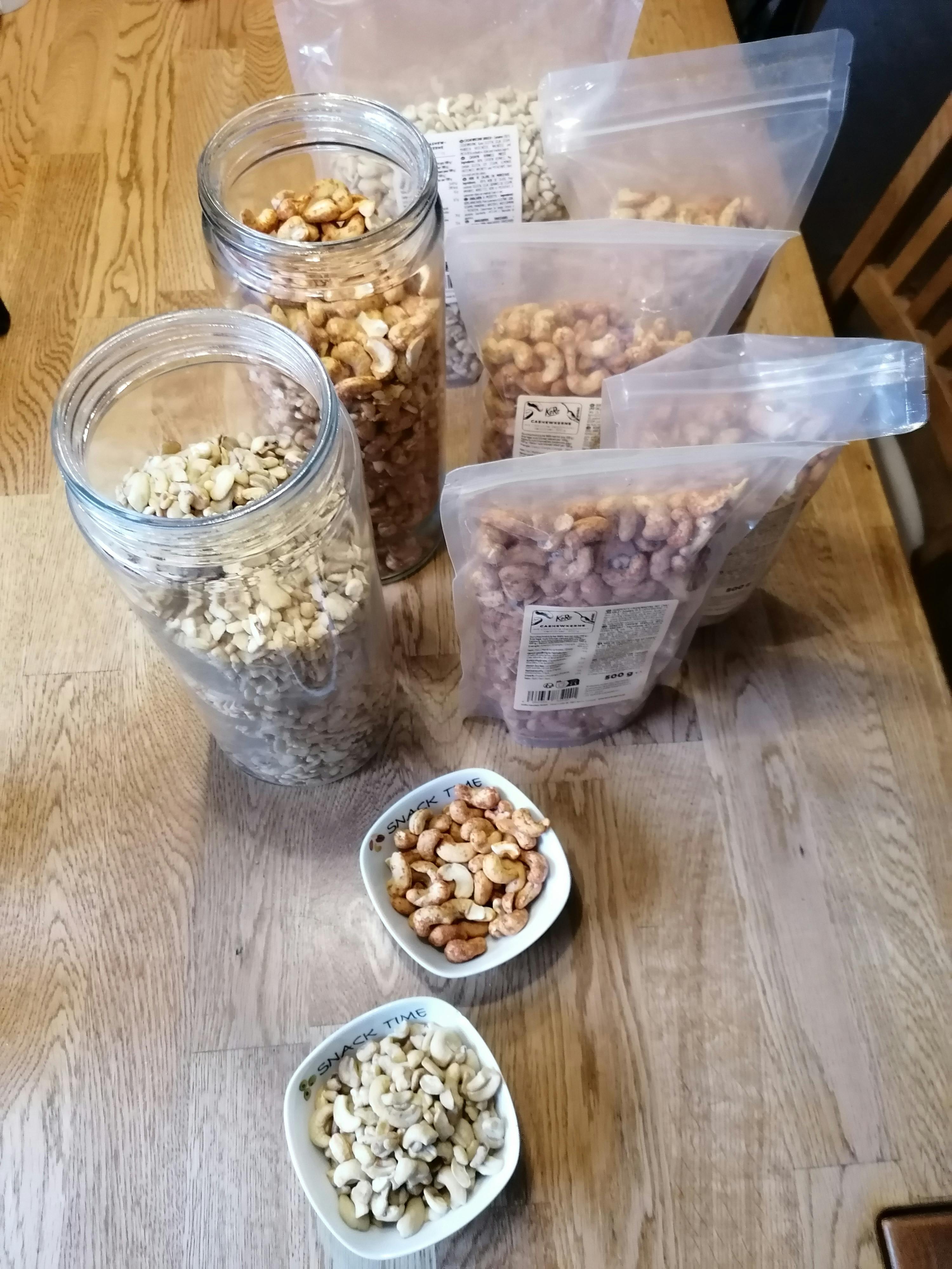a jar of cashews sits on a table next to a bowl of cashews