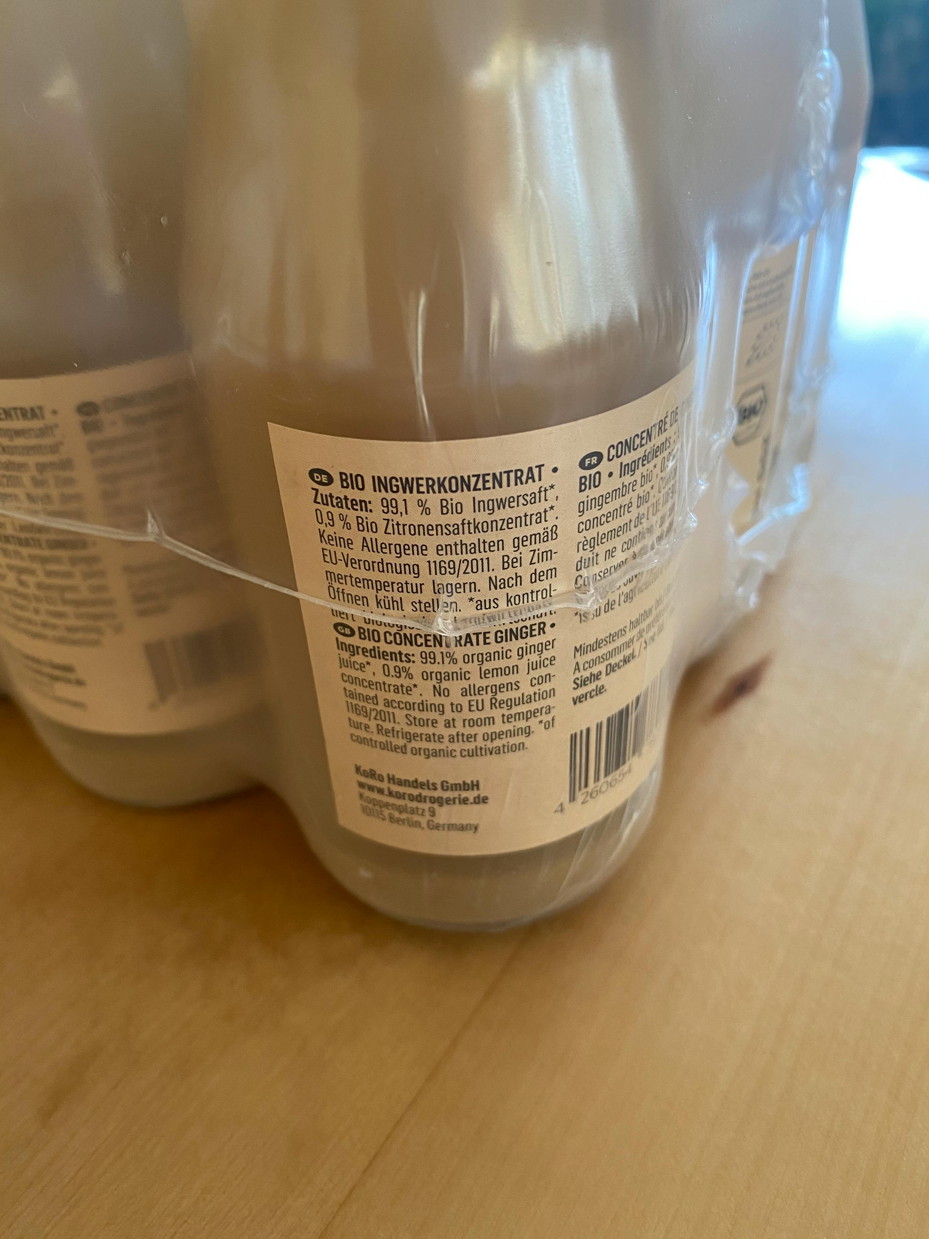 una bottiglia di succo di zenzero biologico è seduta su un tavolo di legno