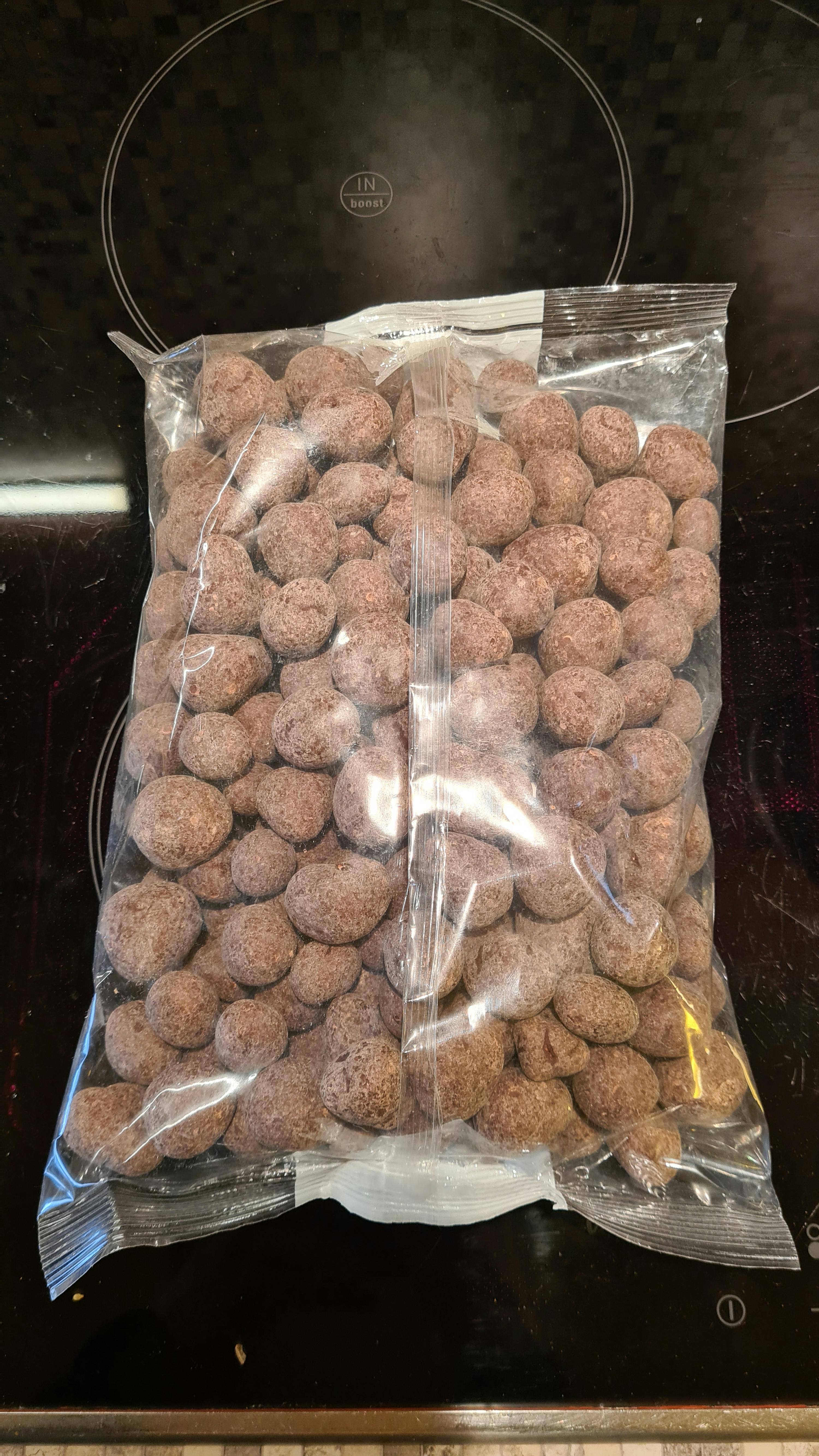 eine Plastiktüte mit Schokoladen-Mandeln sitzt auf einem Herd