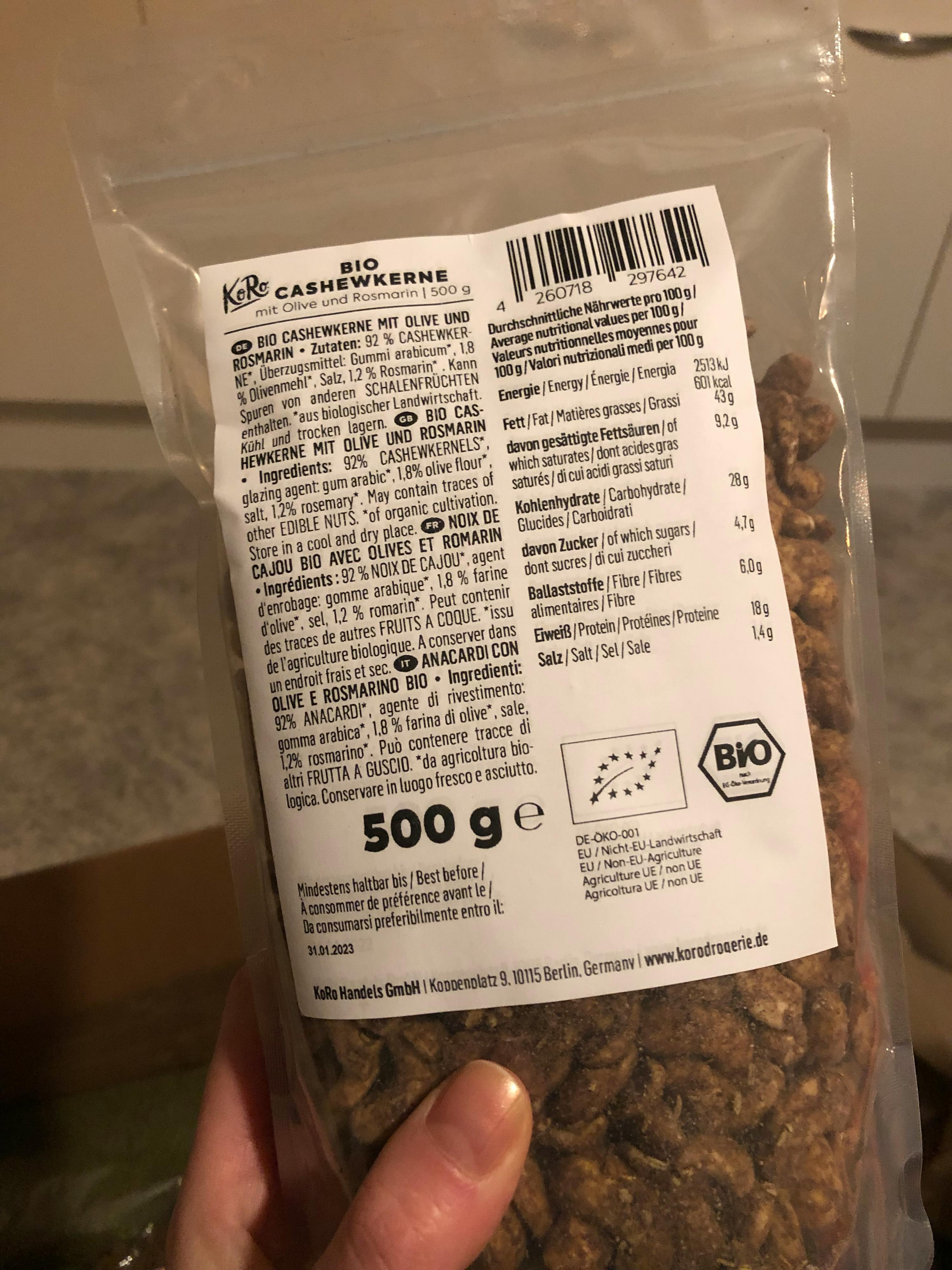 una persona tiene in mano una confezione di cashewkerne bio