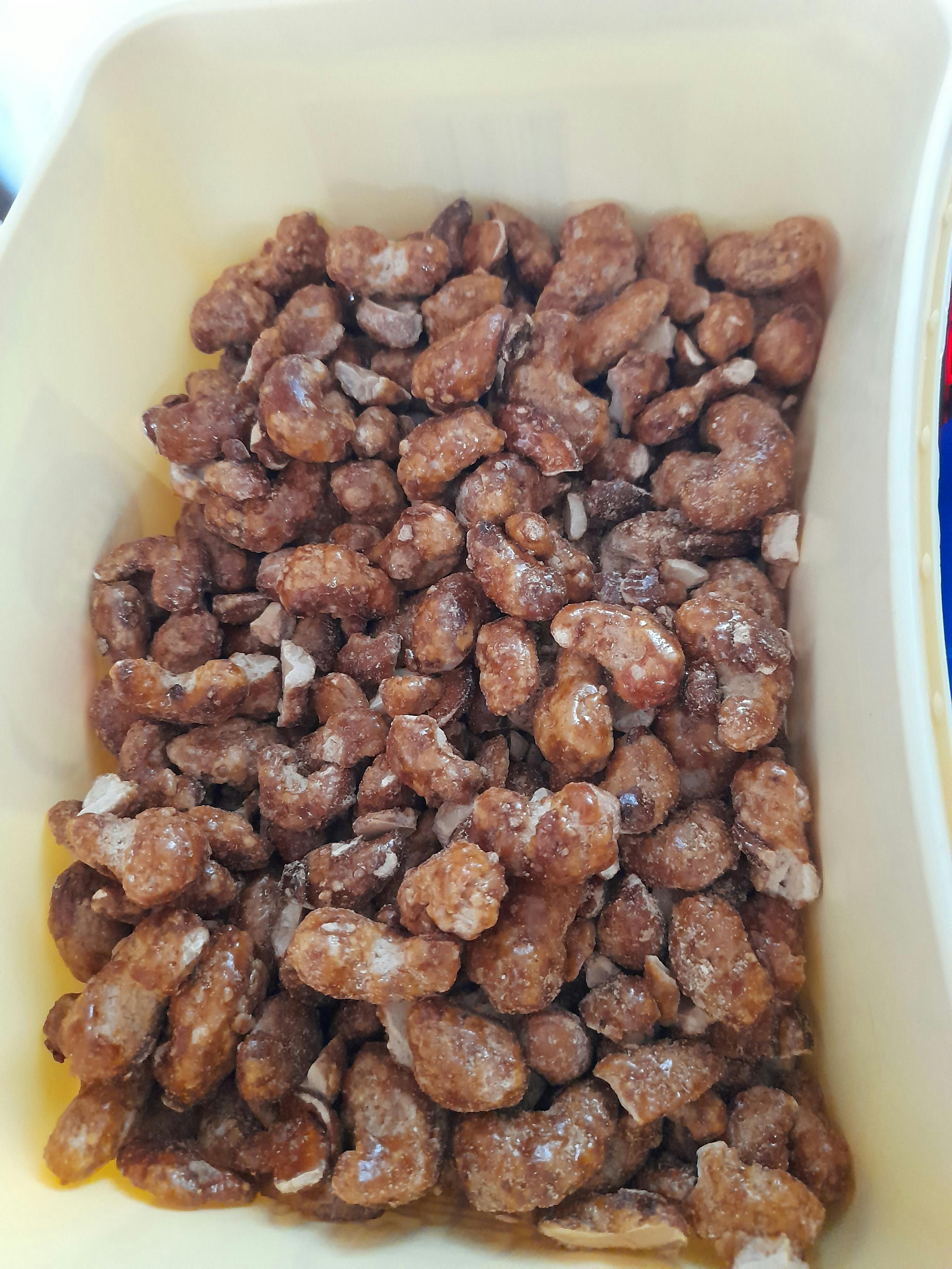 un bol jaune rempli de noix enrobées de caramel