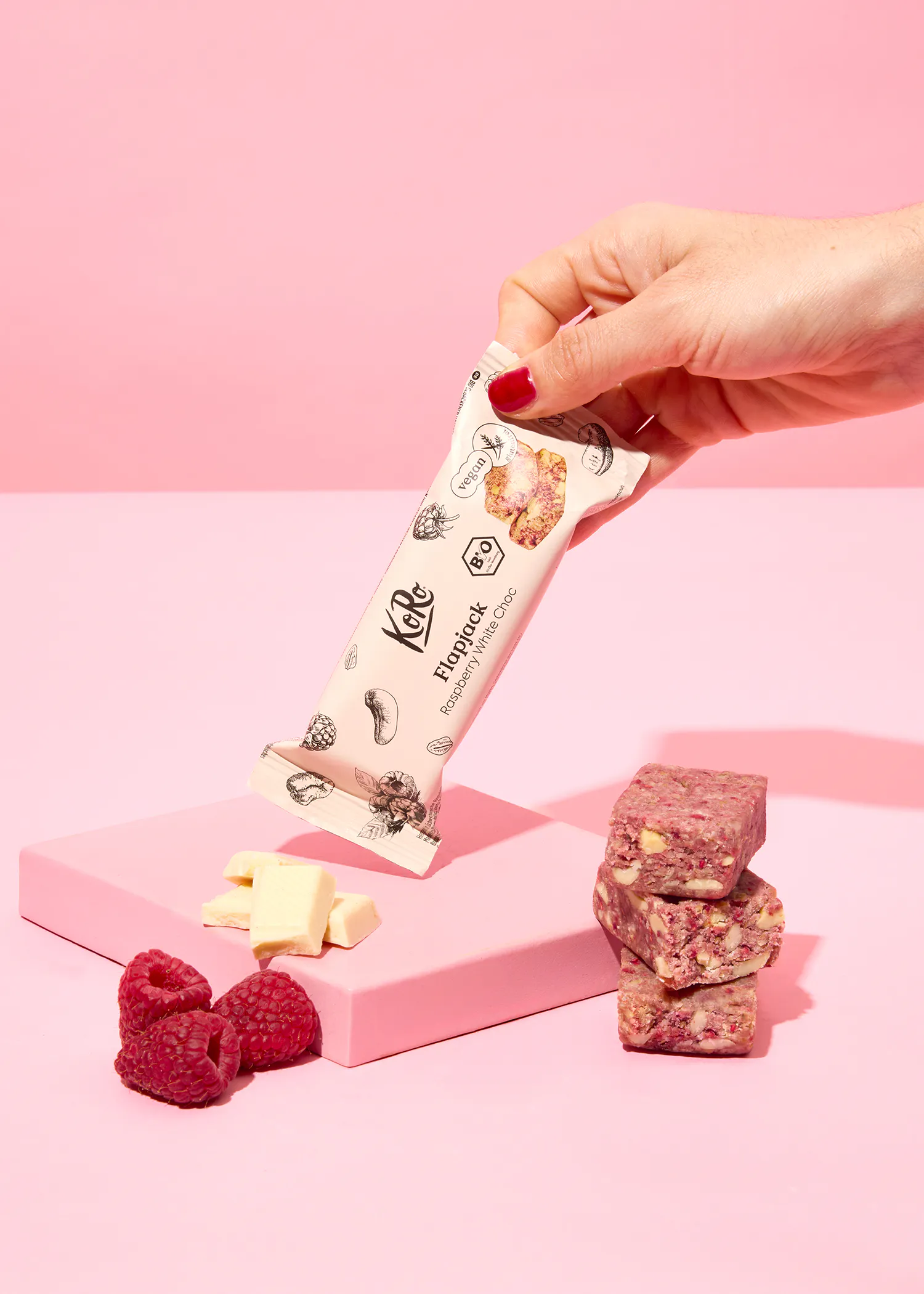 une personne tient une barre de céréales à la framboise