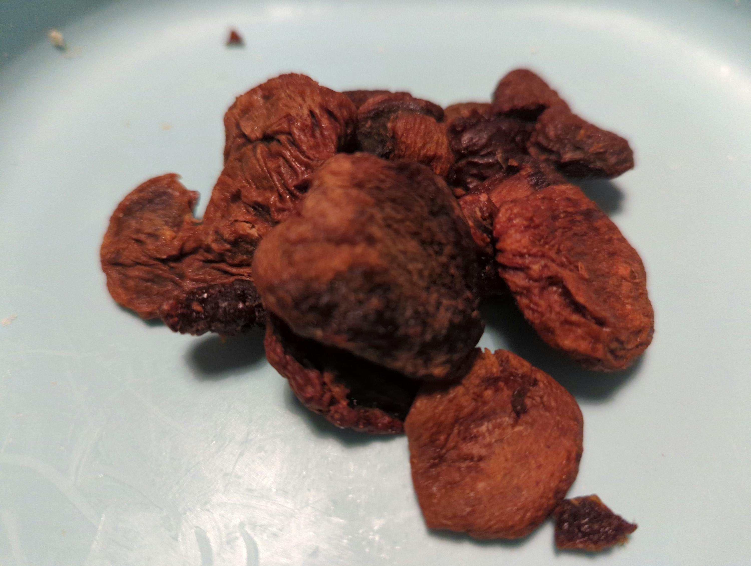 un gros plan d' un tas de fruits secs sur une assiette bleue