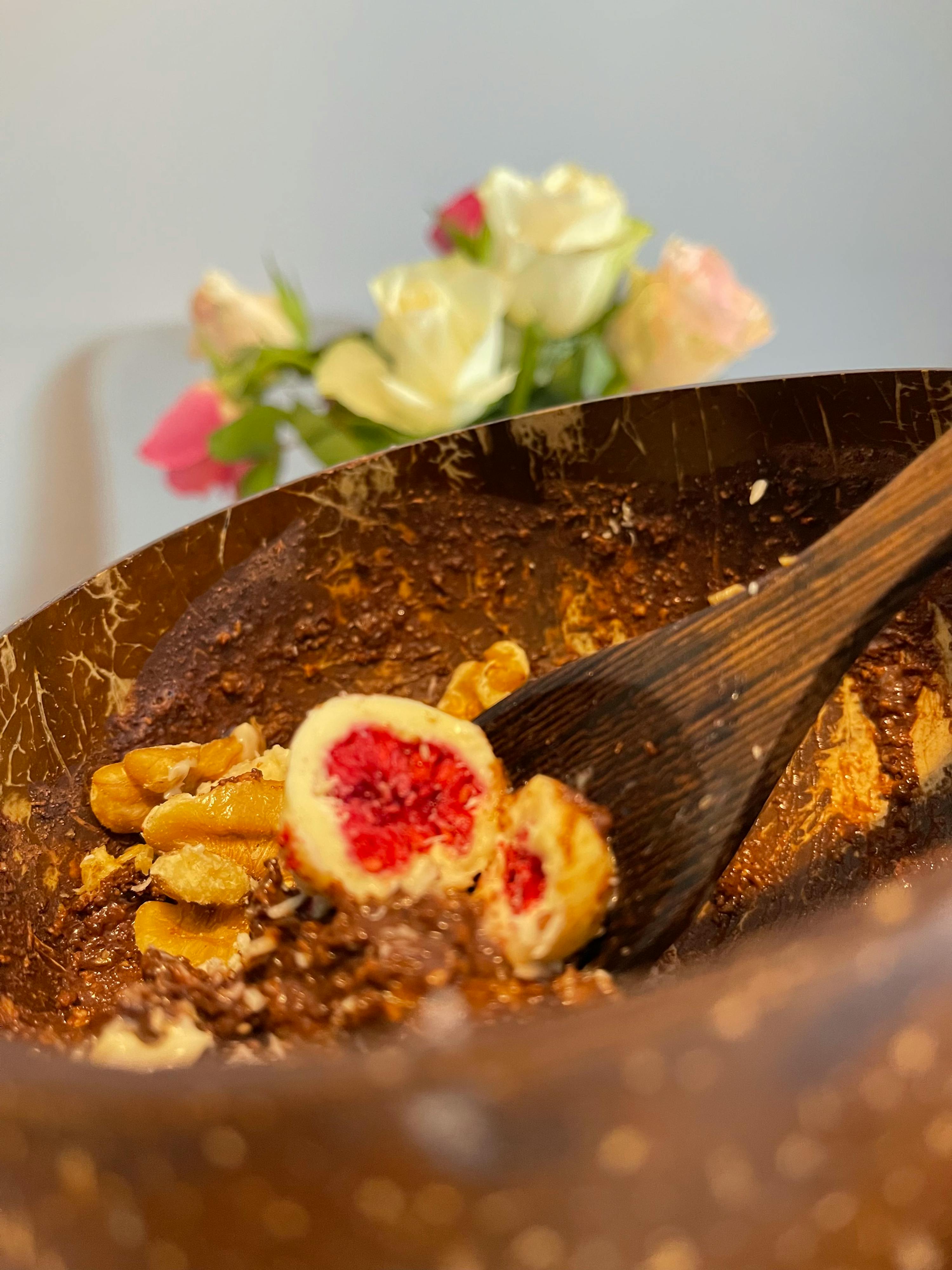 ein Holzlöffel in einer Schüssel mit Schokolade und Walnüssen