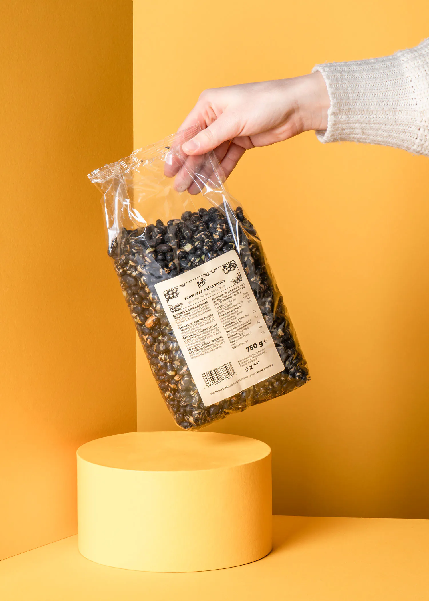 une personne tient un sac de graines de tournesol sur un support jaune