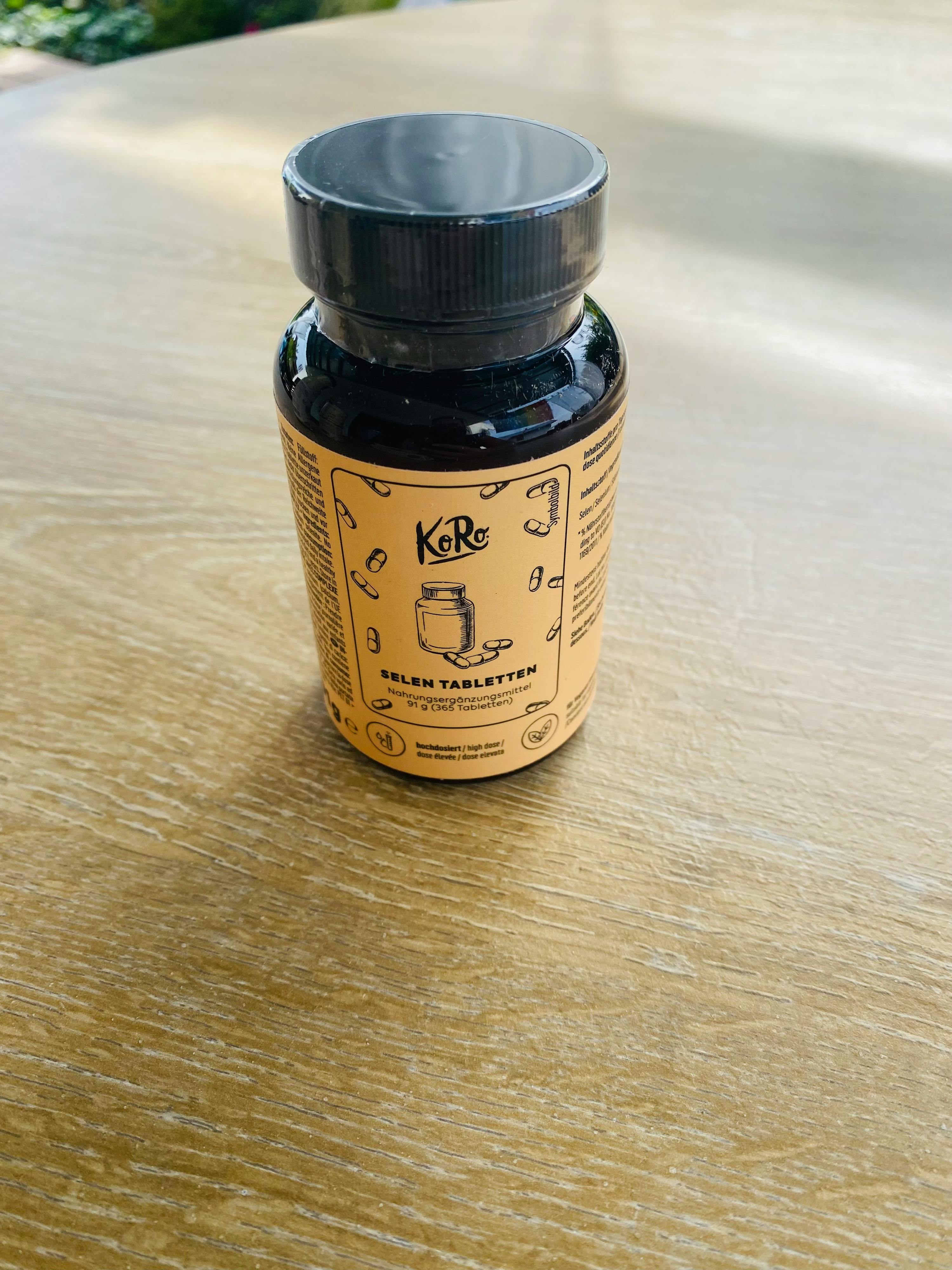eine Flasche selentabletten steht auf einem holztisch