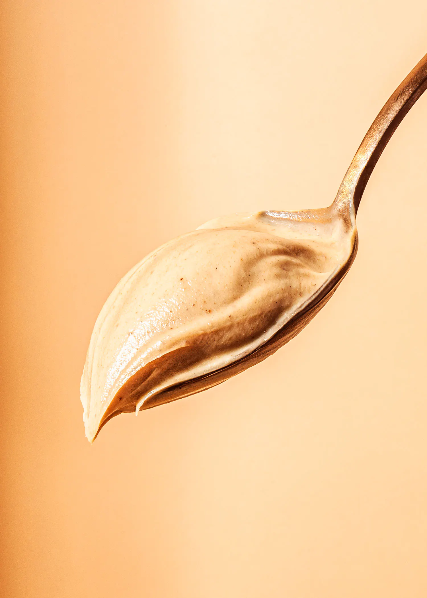 a close up of a spoon filled with peanut butter