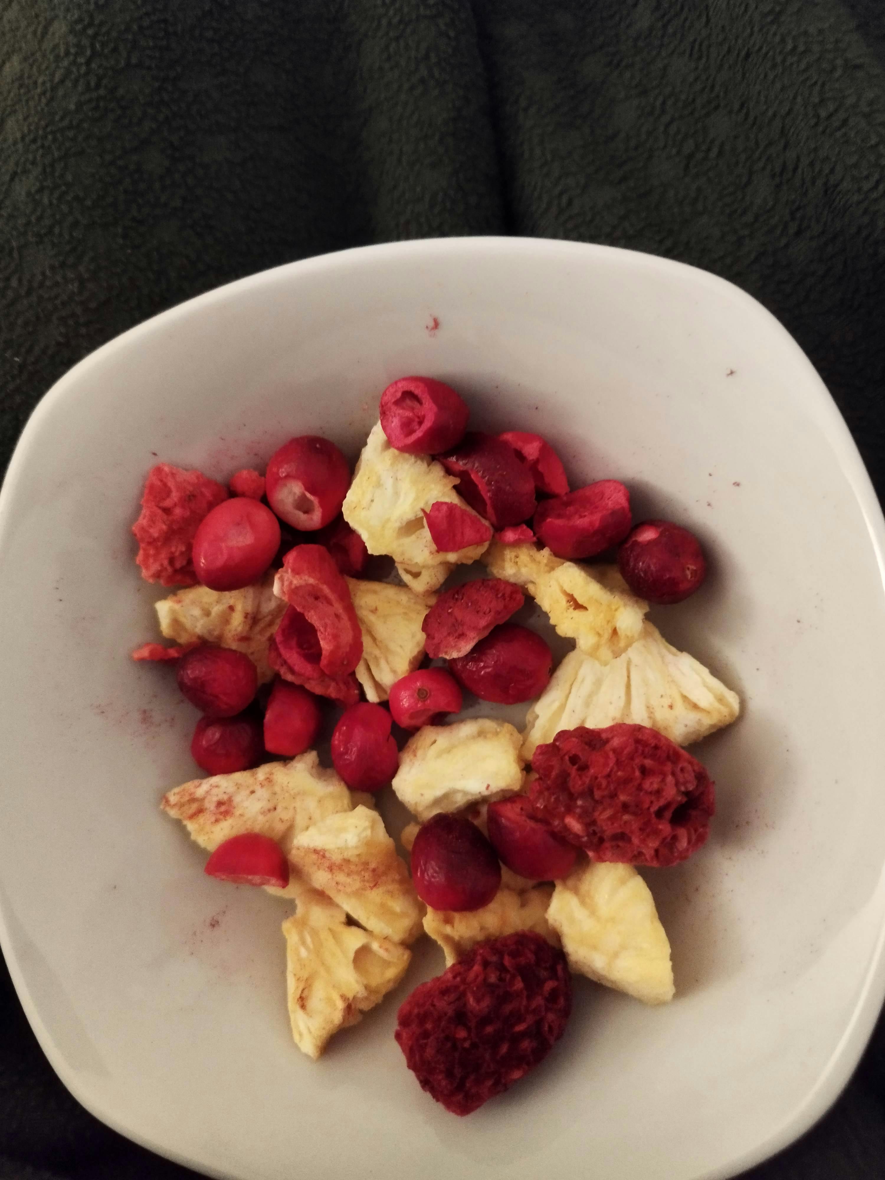 a white bowl filled with dried fruit including cranberries and pineapple