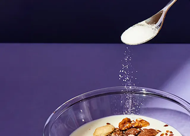 ein Löffel , der Zucker in eine Schüssel gießen lässt