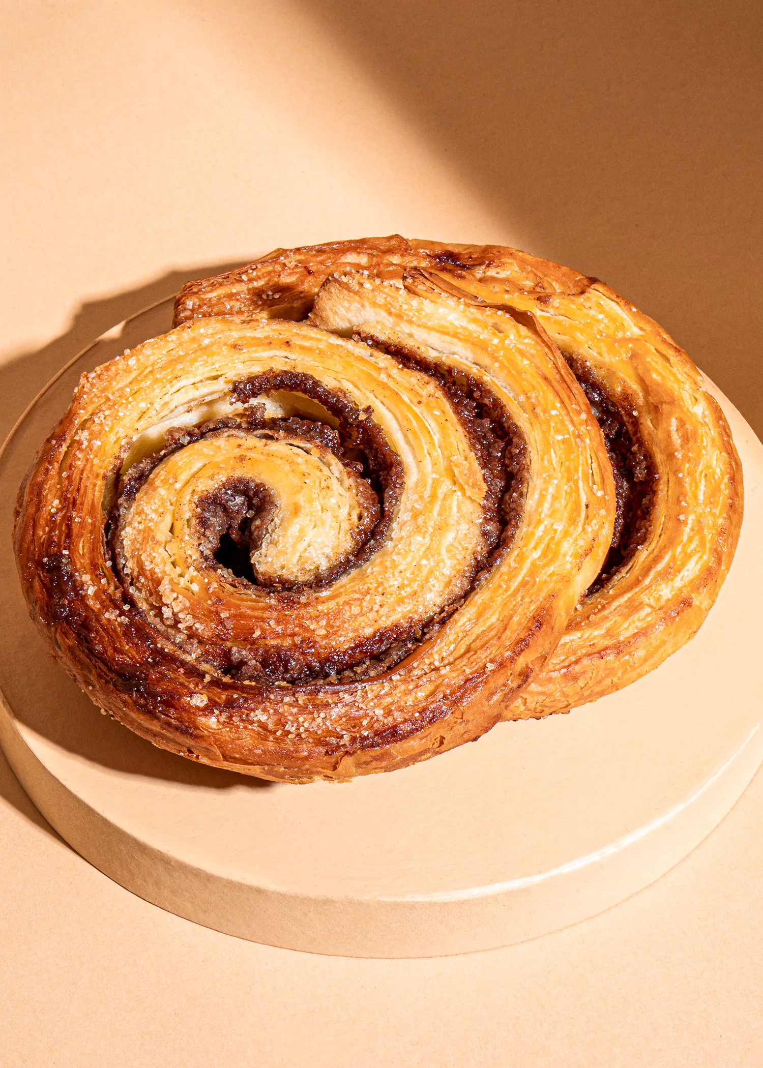 deux pâtisseries spirales sont assises sur une assiette en bois