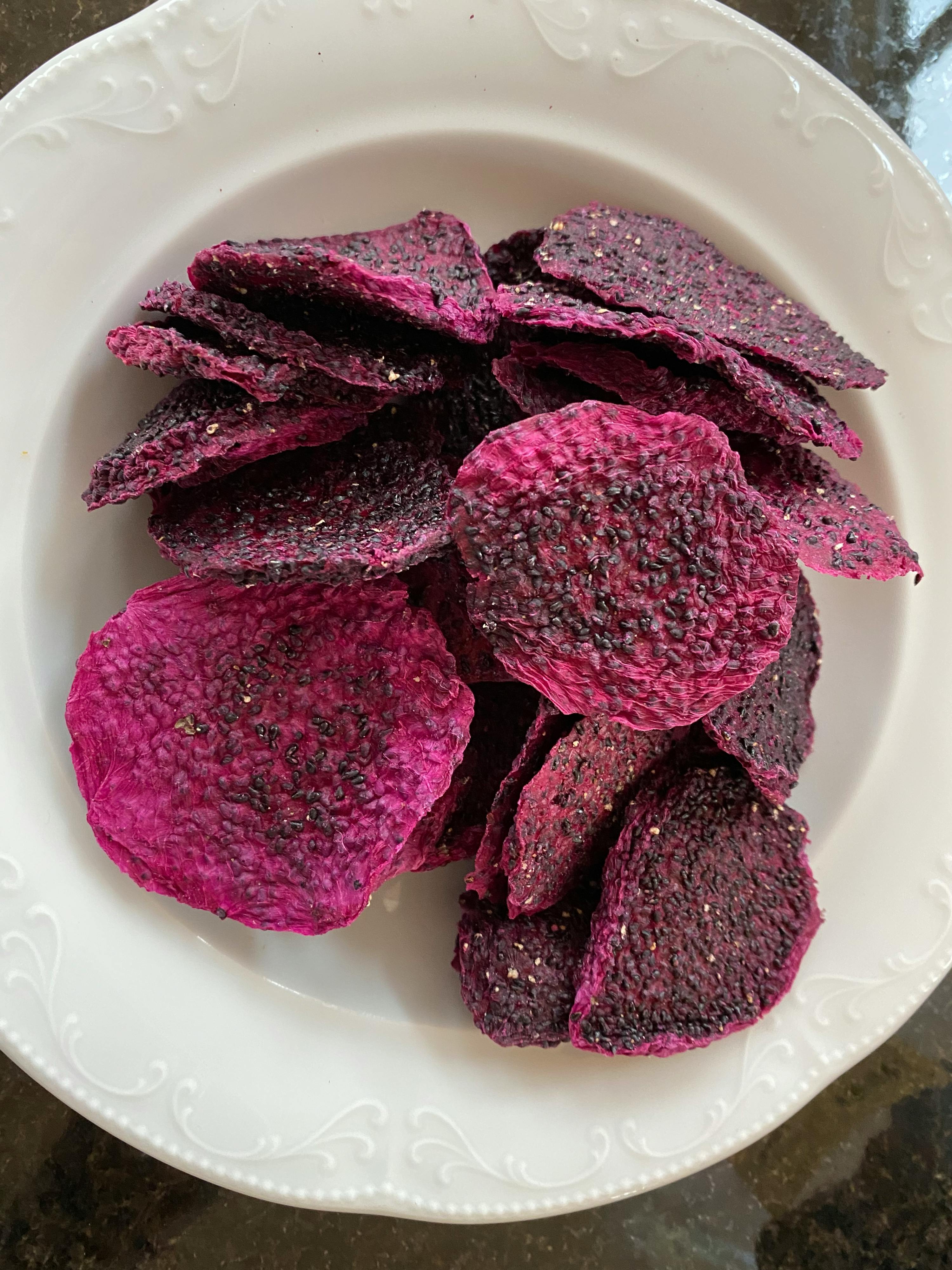 a white plate topped with purple chips on a table