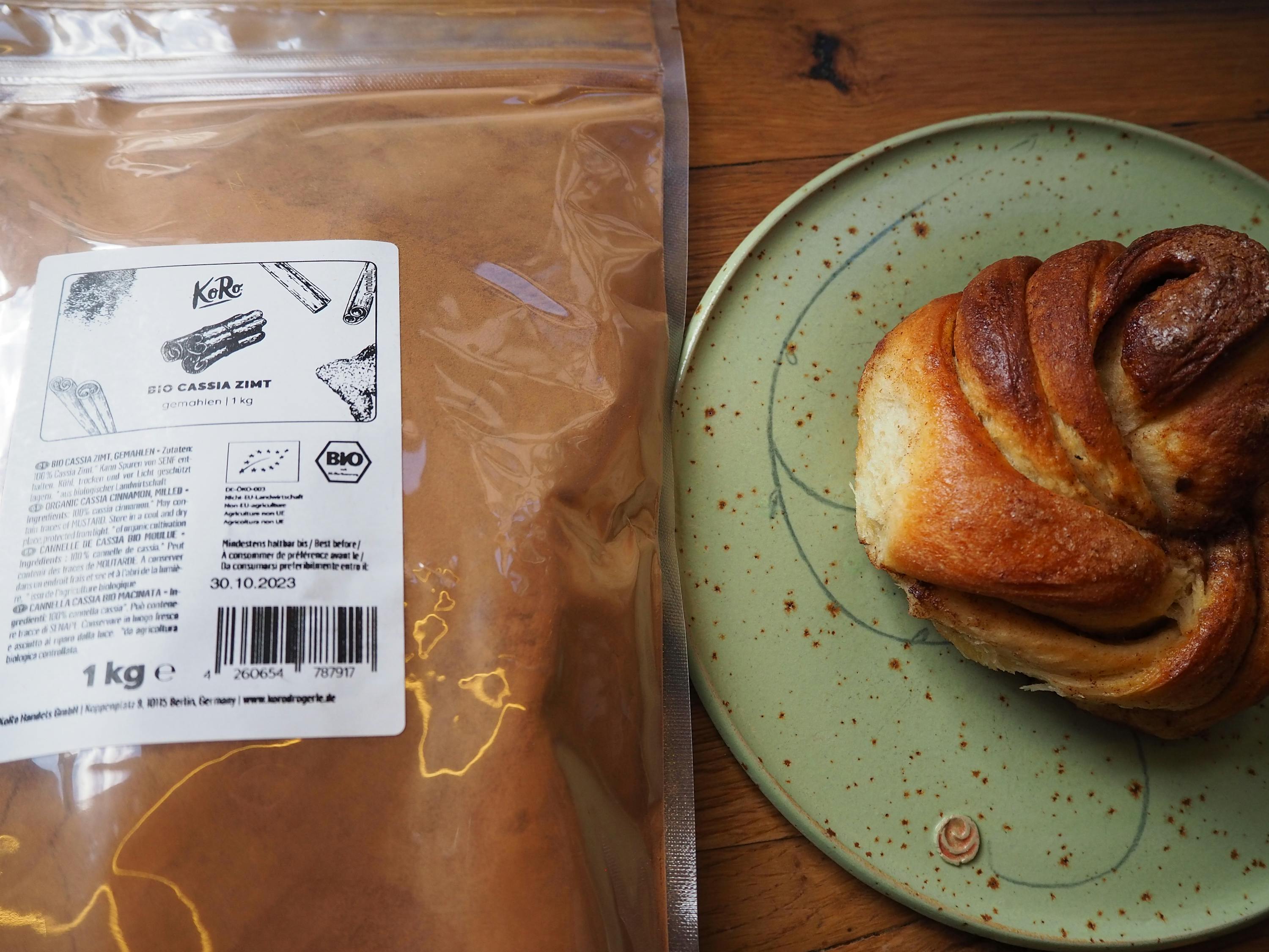une boulangerie sur une assiette verte à côté d' un sac de cannelle bio