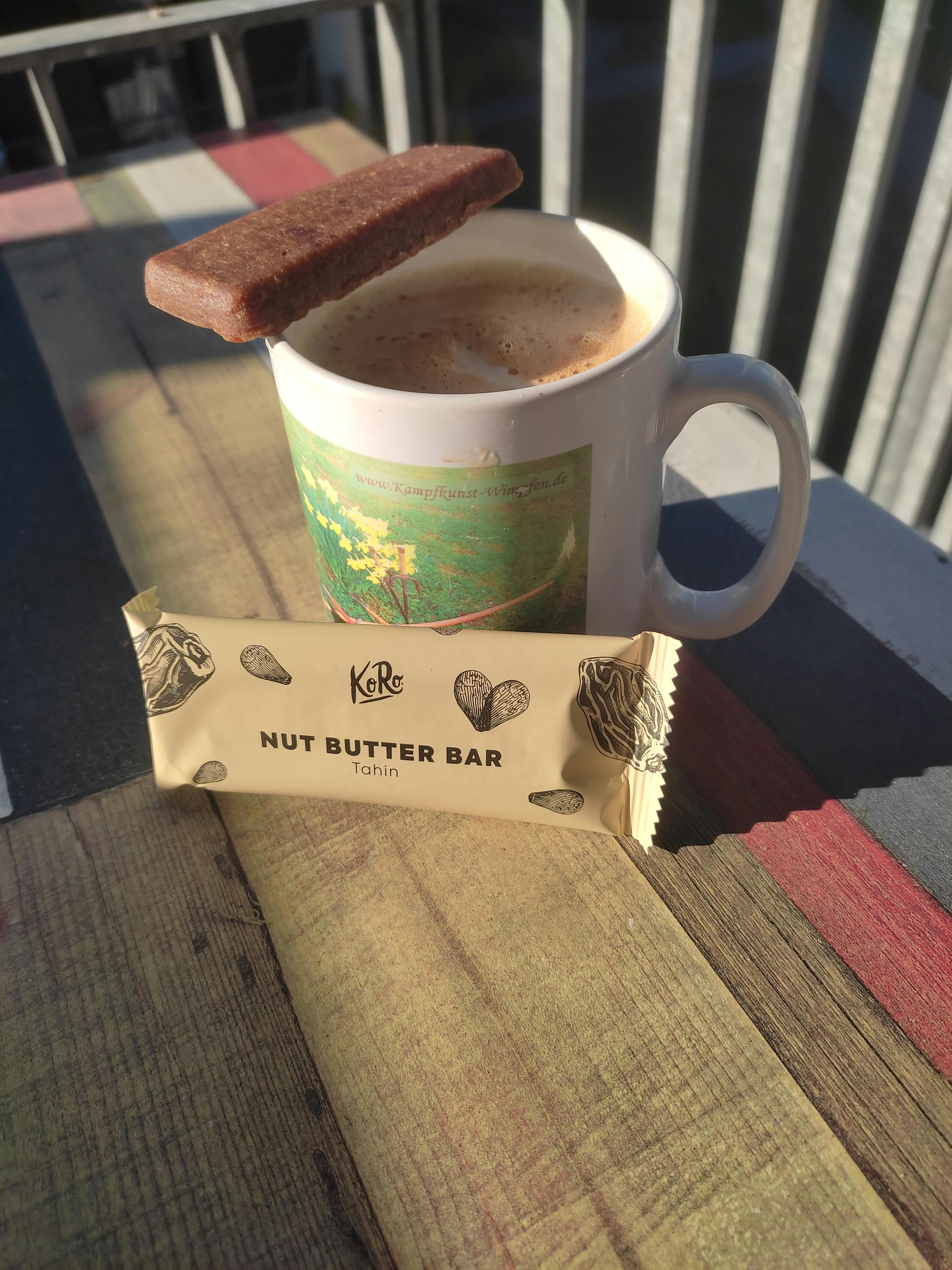 eine kleine Nussbutter-Bar liegt neben einer Tasse Kaffee