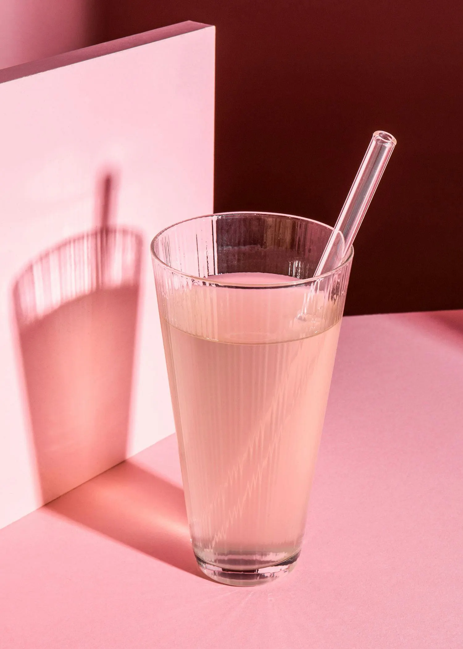 a glass of liquid with a straw in it