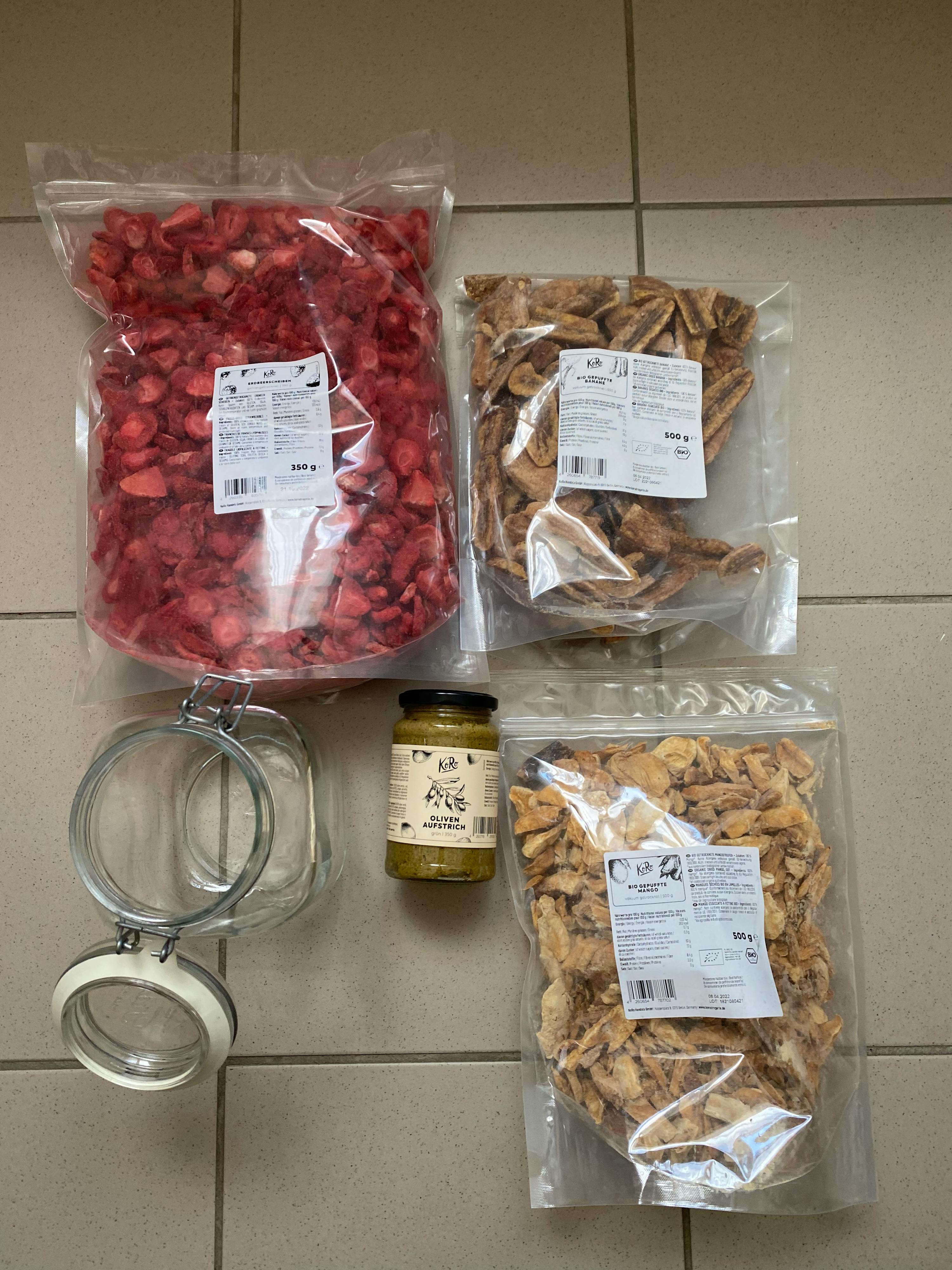 a jar of pesto sits next to a bag of strawberries