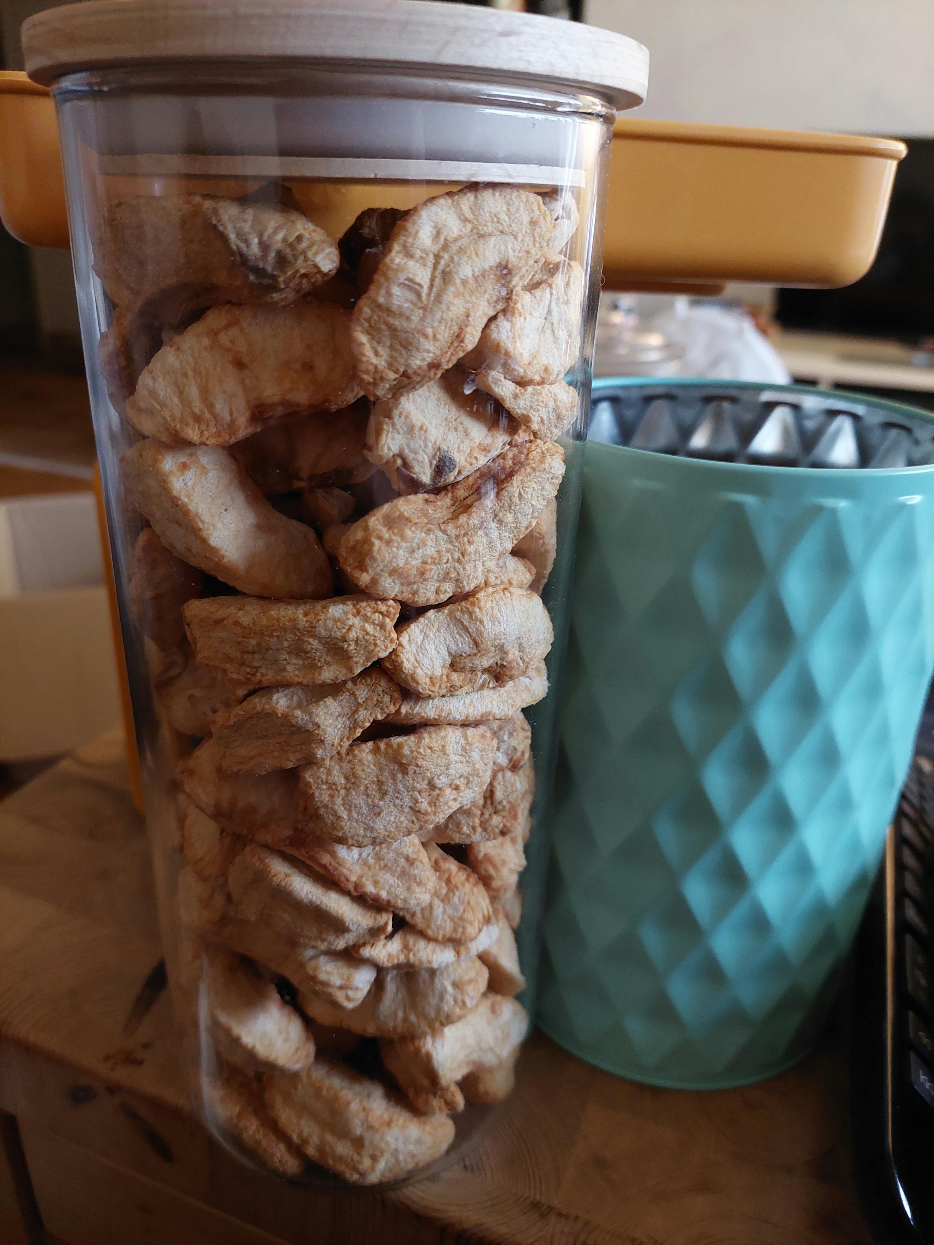 a jar of dried apples sits on a counter