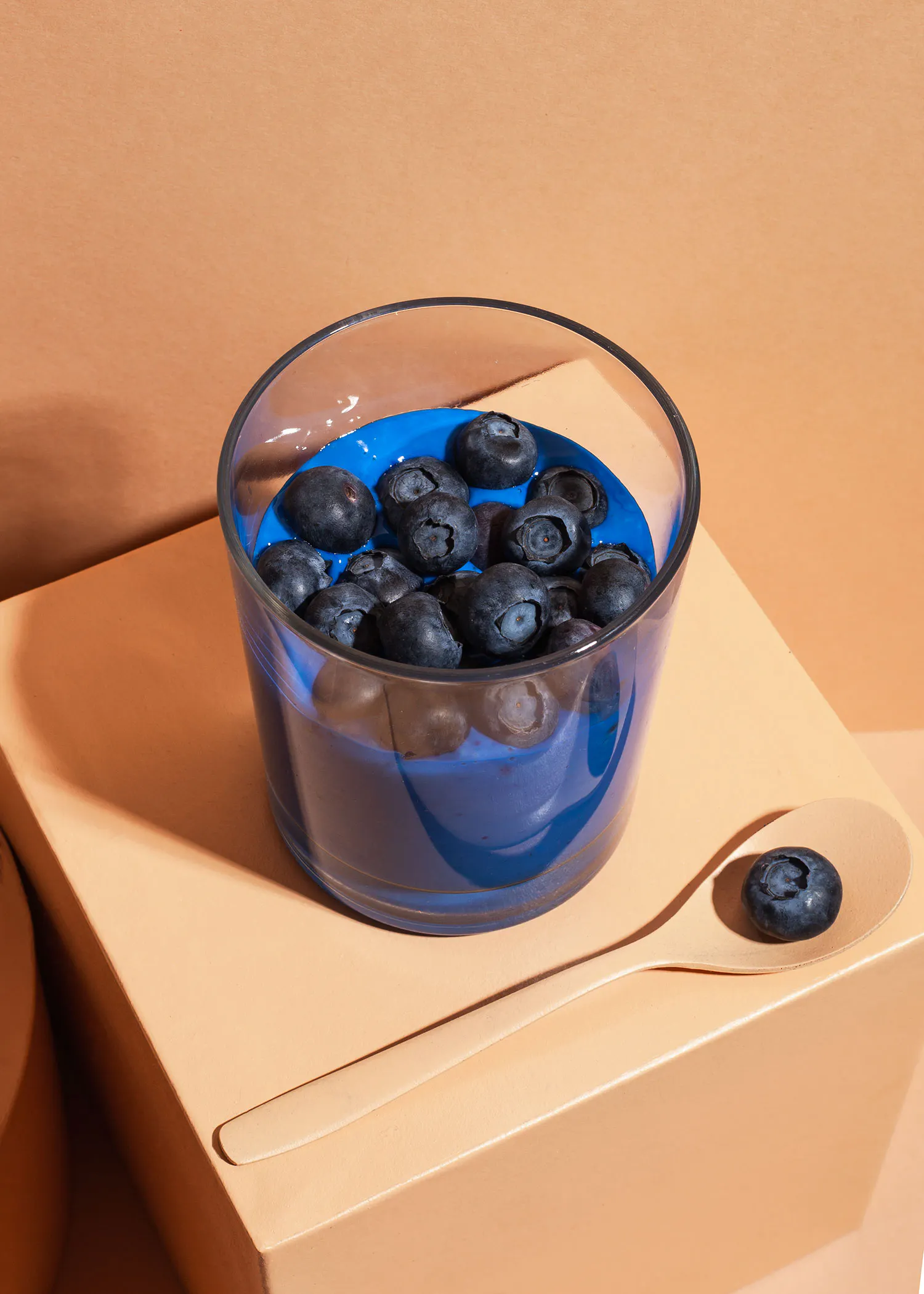 ein Glas mit Blaubeeren und einem Holzlöffel darin