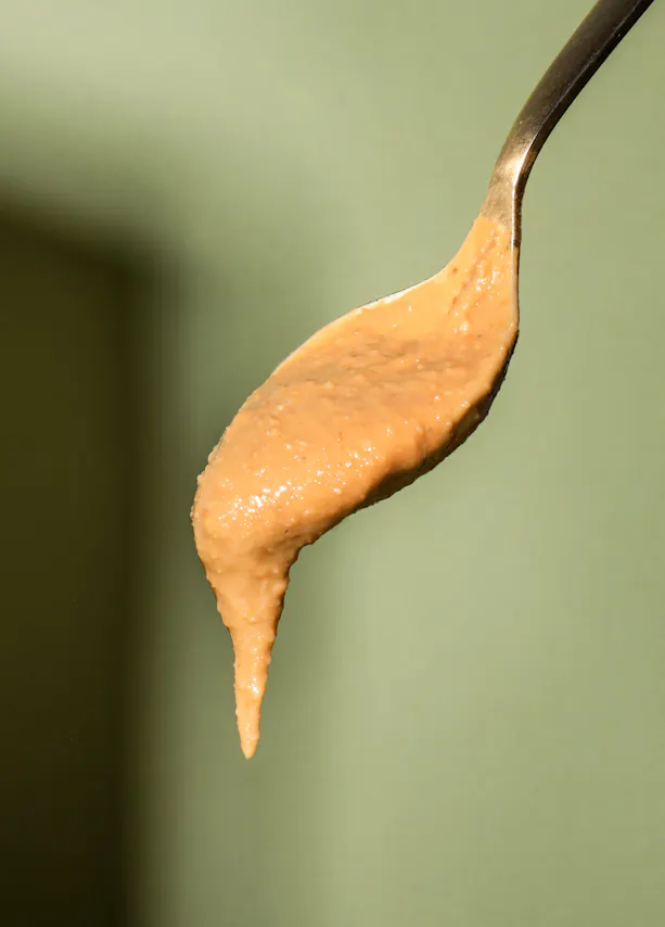 a close up of a spoon filled with peanut butter