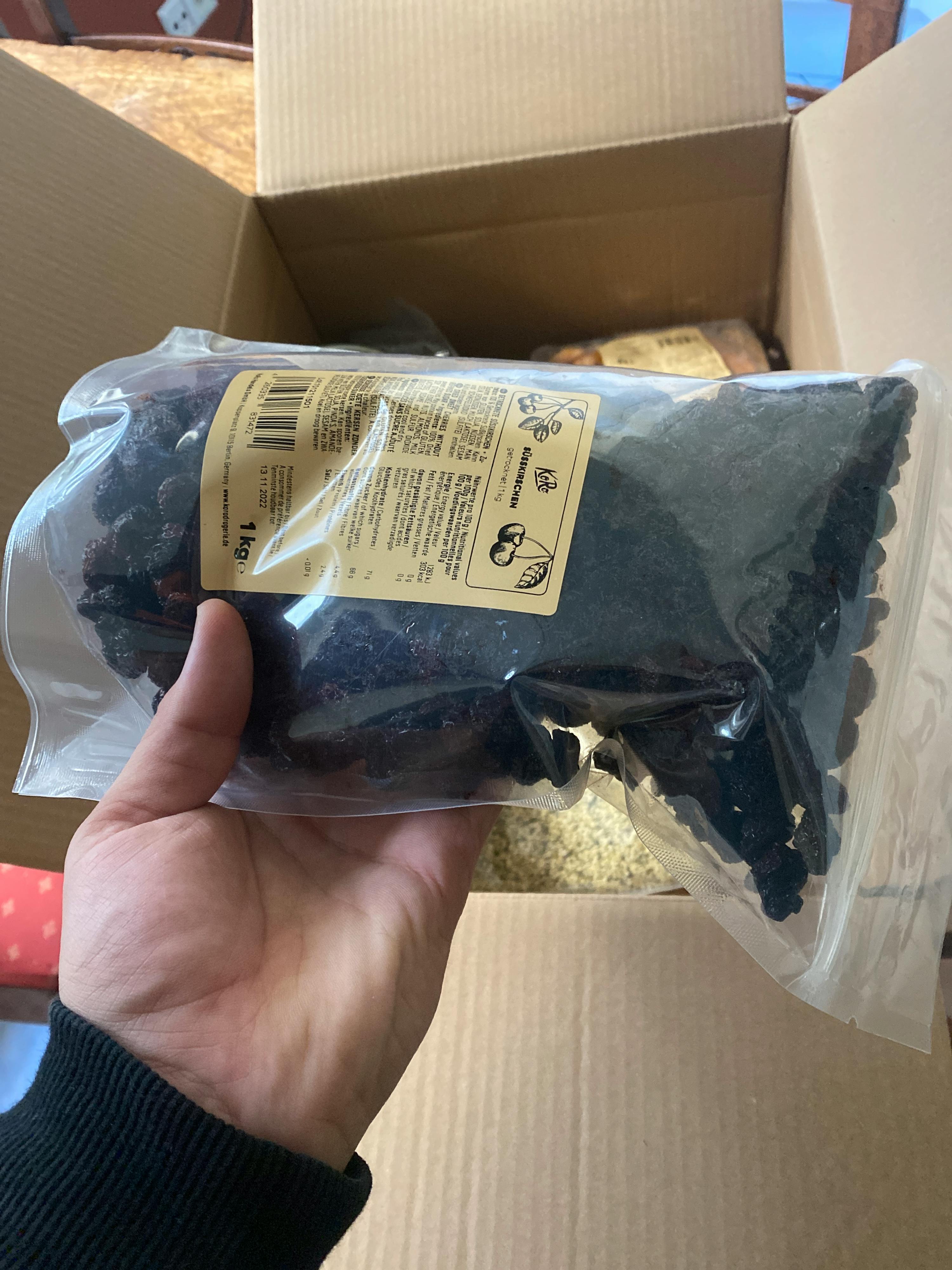 une personne tient un sac de cerise séchée dans sa main