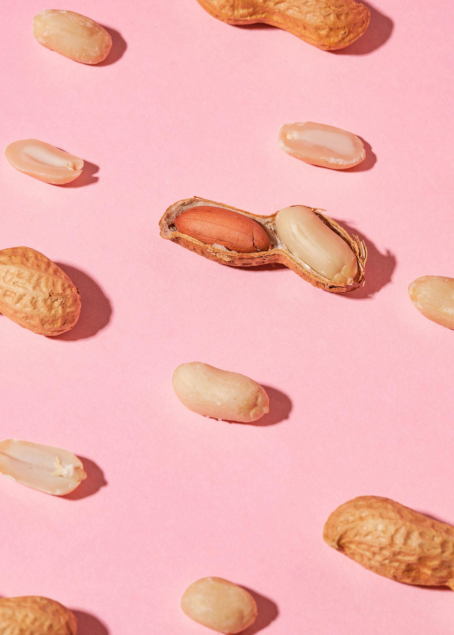 eine Erdnuss in der Schale auf einem rosa Hintergrund