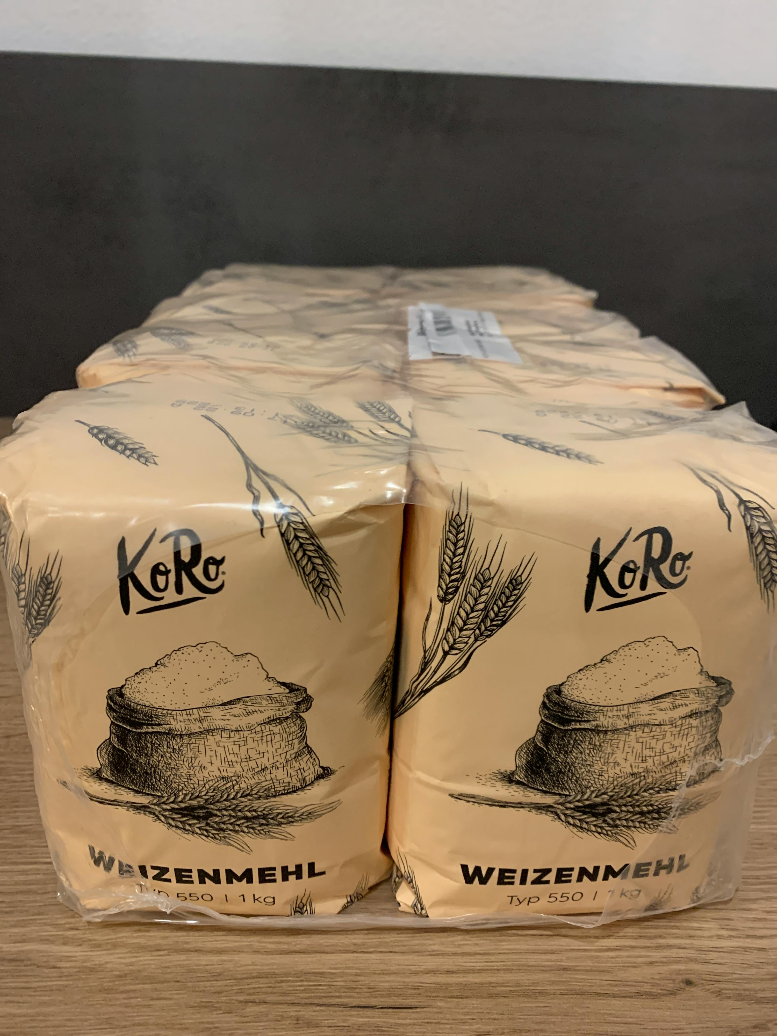 due sacchetti di farina di grano sono impilati uno sopra l' altro su un tavolo di legno