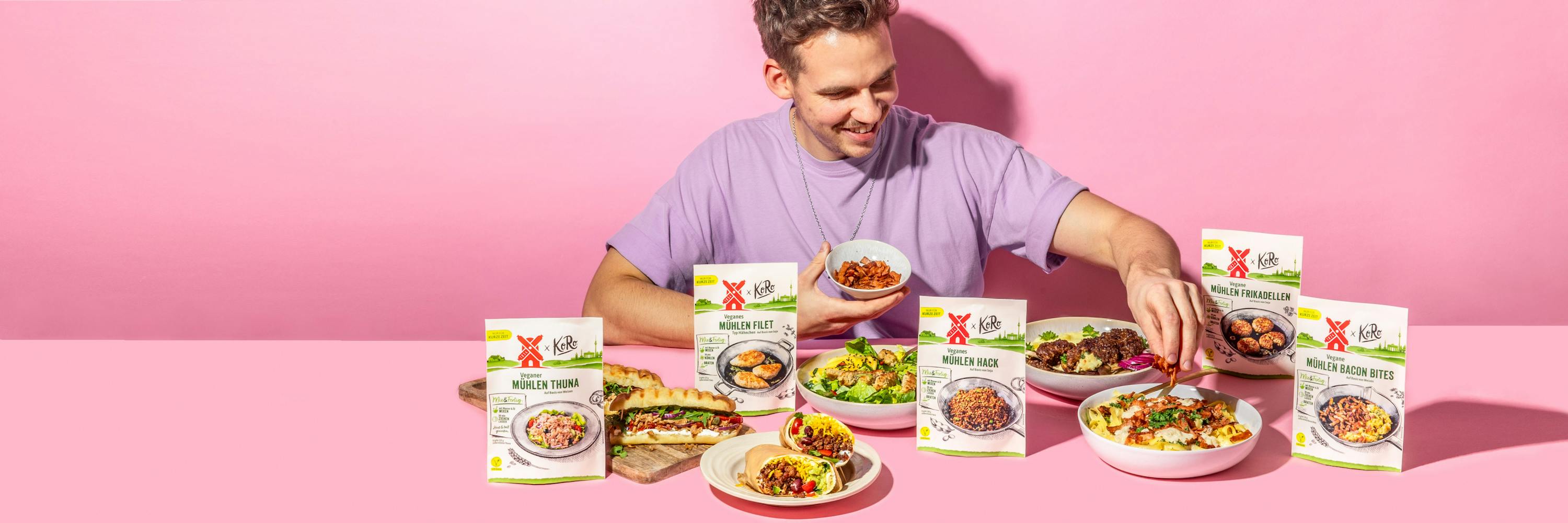 un uomo è seduto a un tavolo circondato da cibo pronto a mangiare