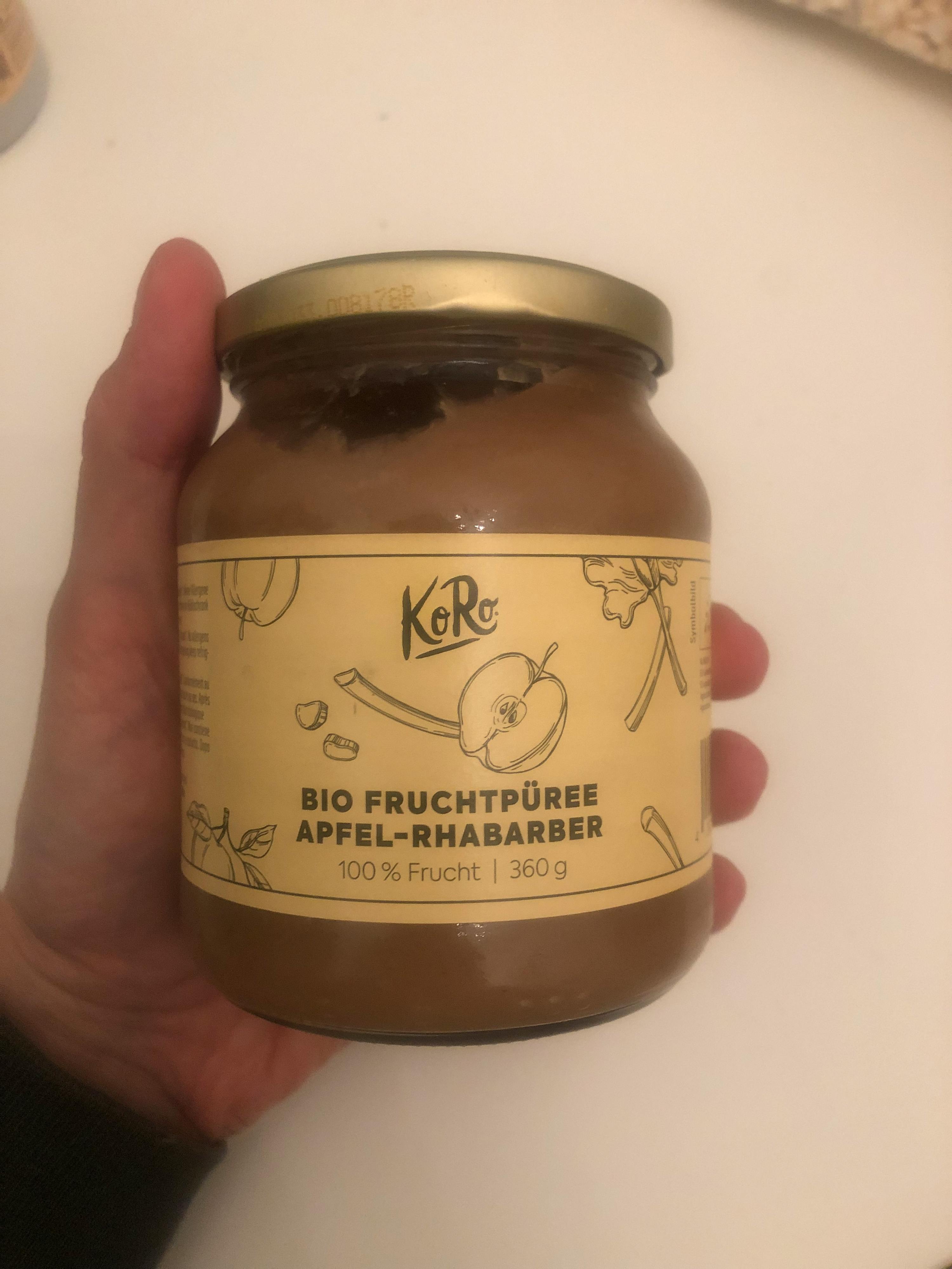 una persona tiene in mano un barattolo di marmellata di mele