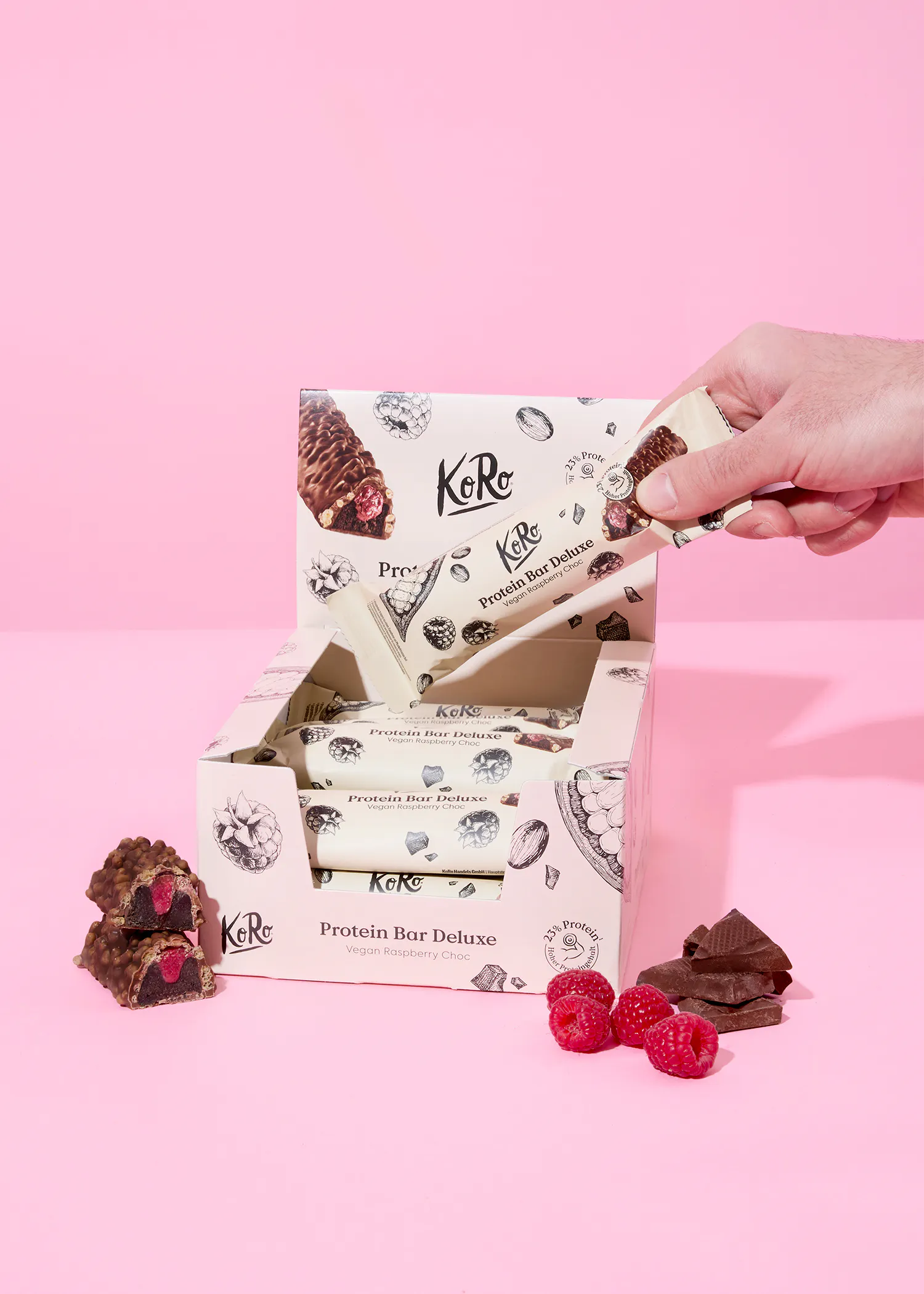 a person is holding a protein bar in front of a box of protein bars