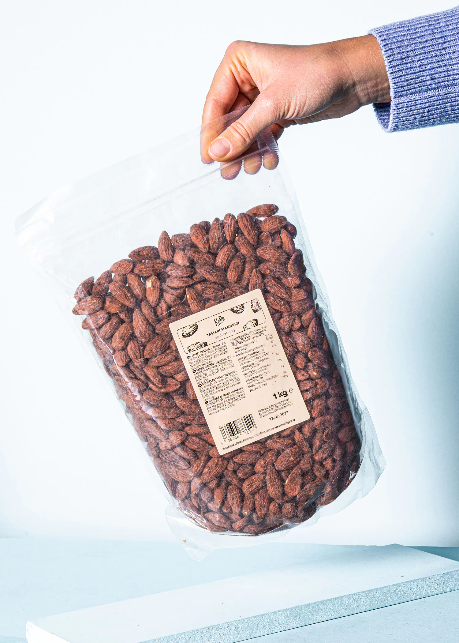 une personne tient un sac d' amandes avec une étiquette sur le sac