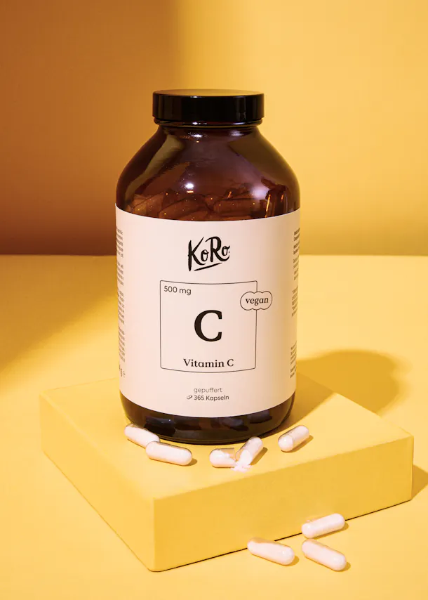 a bottle of kore vitamin c is on a yellow surface