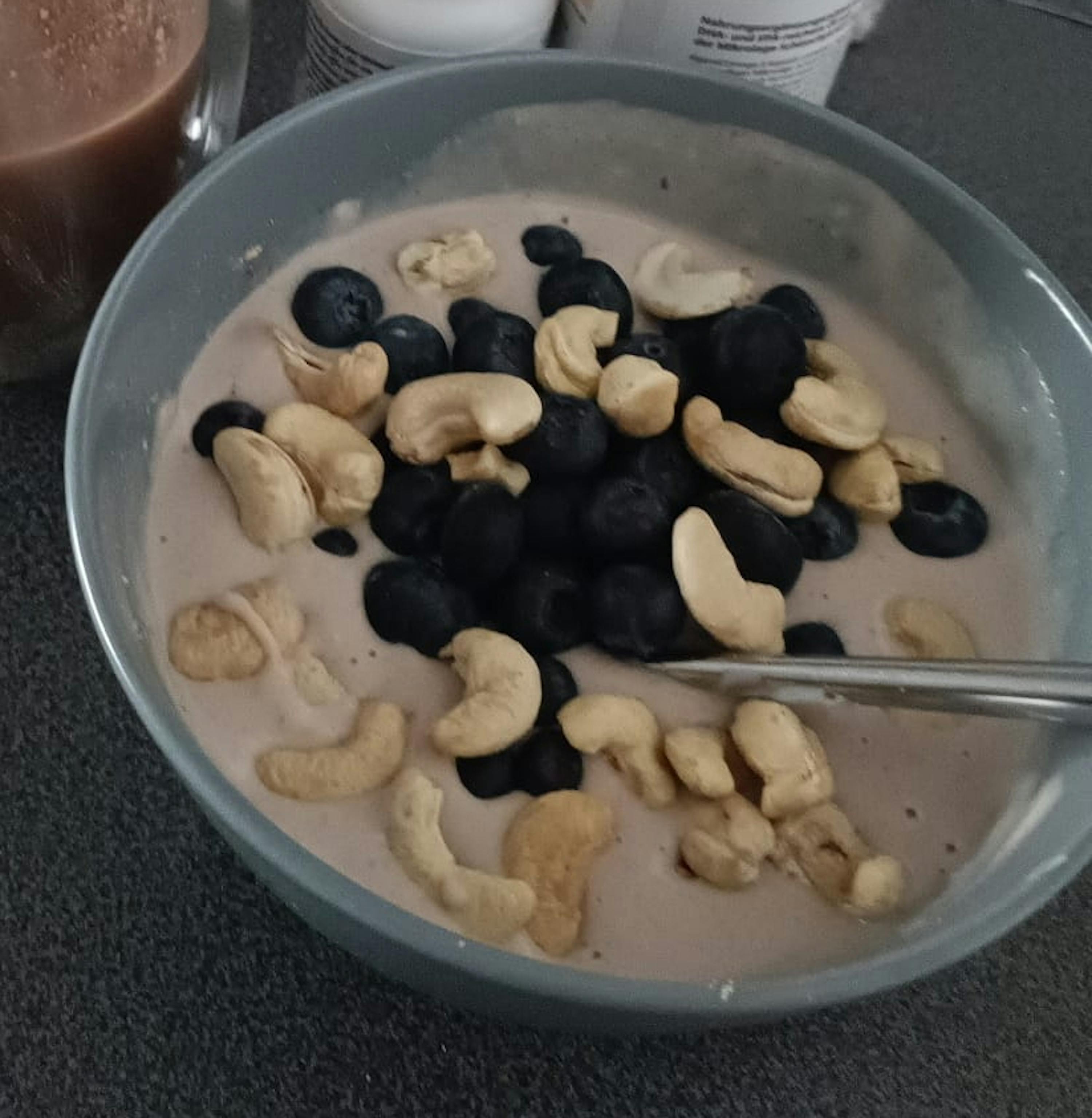 eine Schüssel Milch mit Blaubeeren und Cashewnüssen